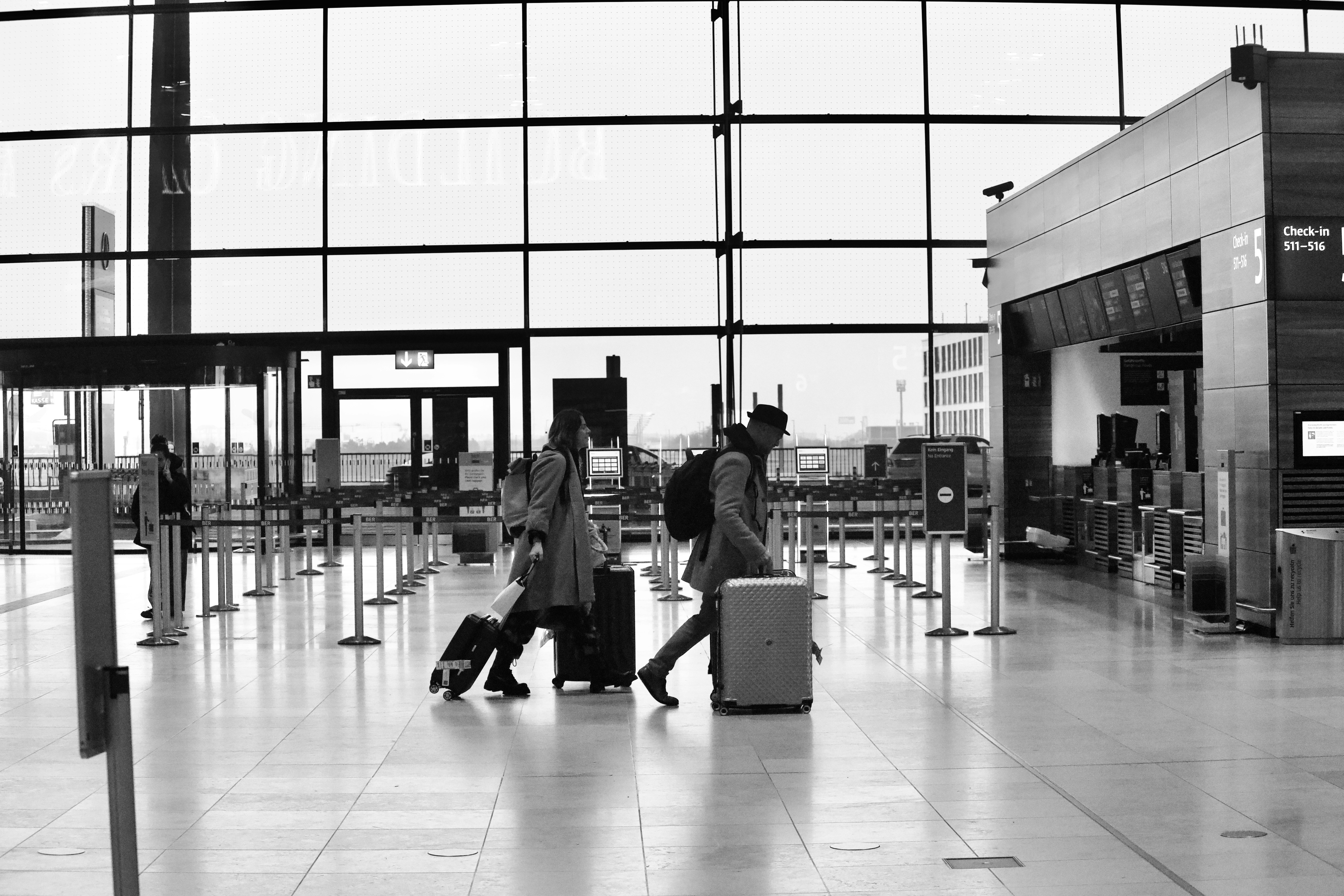 Una pareja arrastrando su equipaje por la terminal de un aeropuerto | Fuente: Unsplash