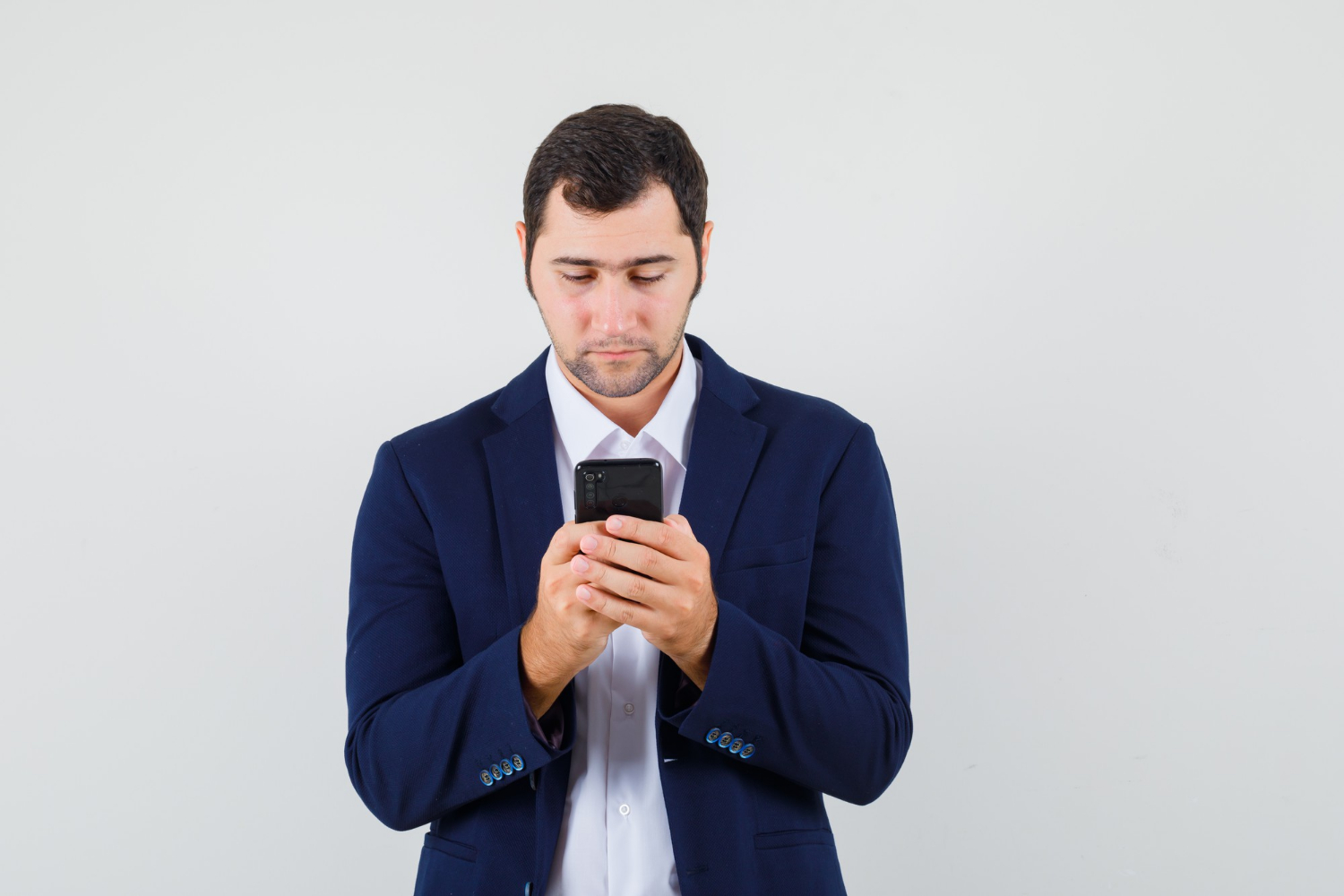 Un hombre angustiado mirando su teléfono | Fuente: Freepik