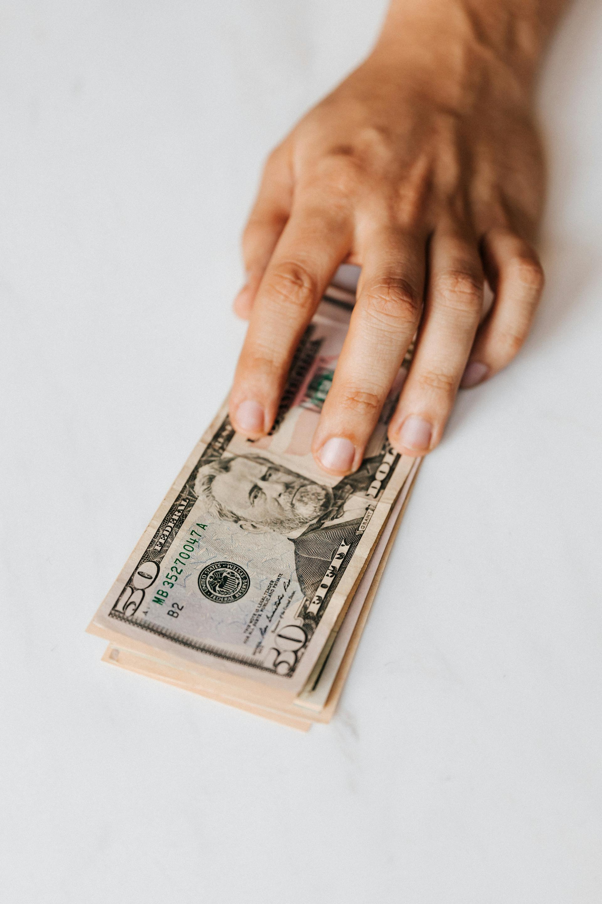 Un hombre con dinero en la mano | Fuente: Pexels