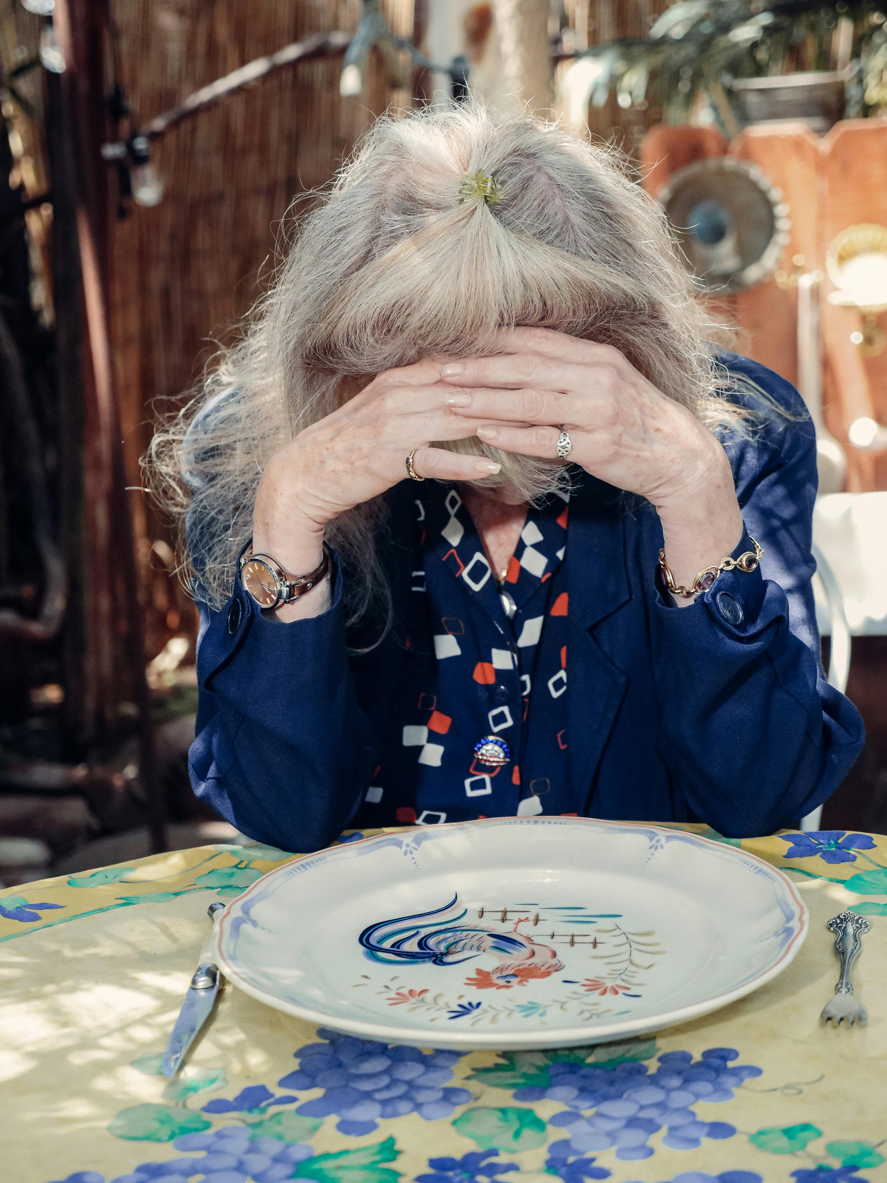 Mujer mayor cubriéndose la cara | Fuente: Pexels