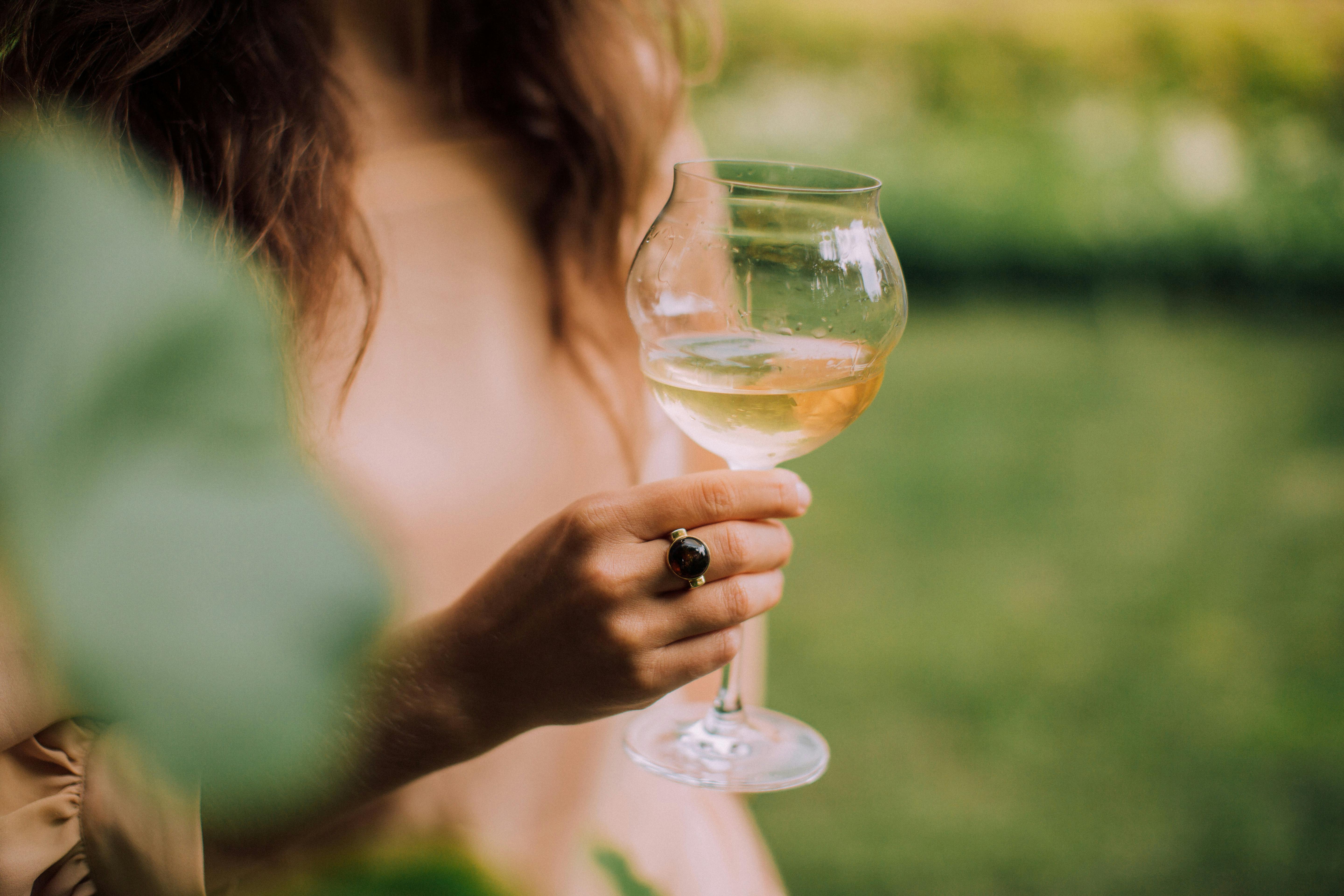 Una mujer con una copa de vino en la mano | Fuente: Pexels