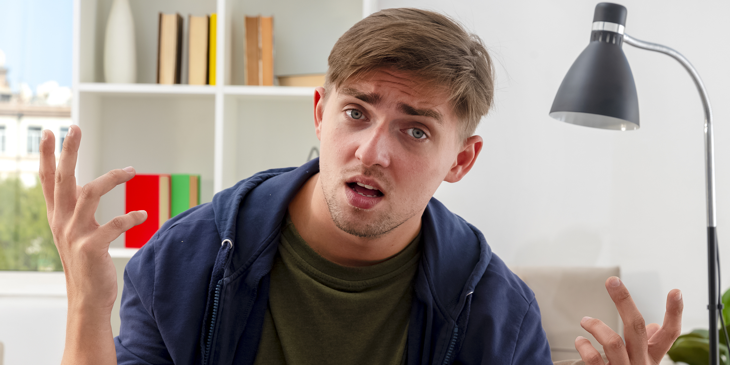Un joven confuso y frustrado sentado en casa | Fuente: Freepik