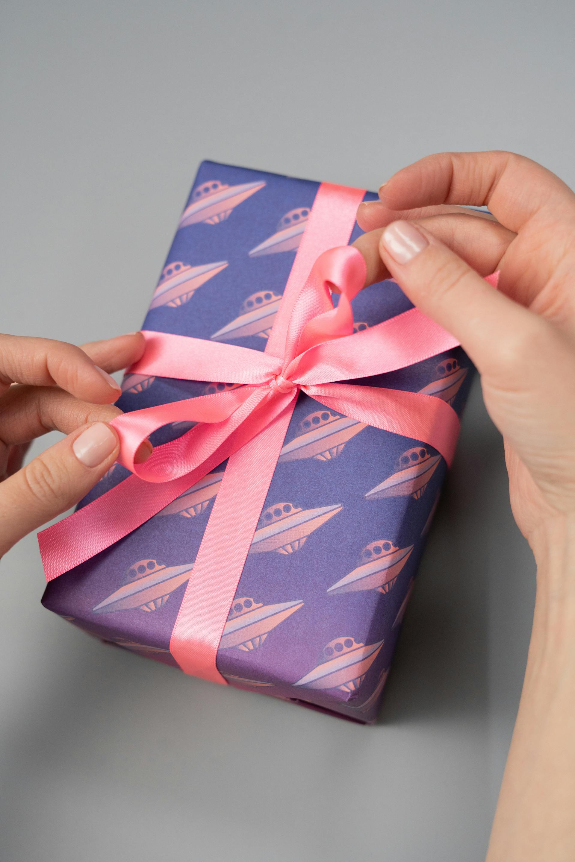Primer plano de una persona que sostiene una caja de regalo con un lazo rosa | Fuente: Pexels