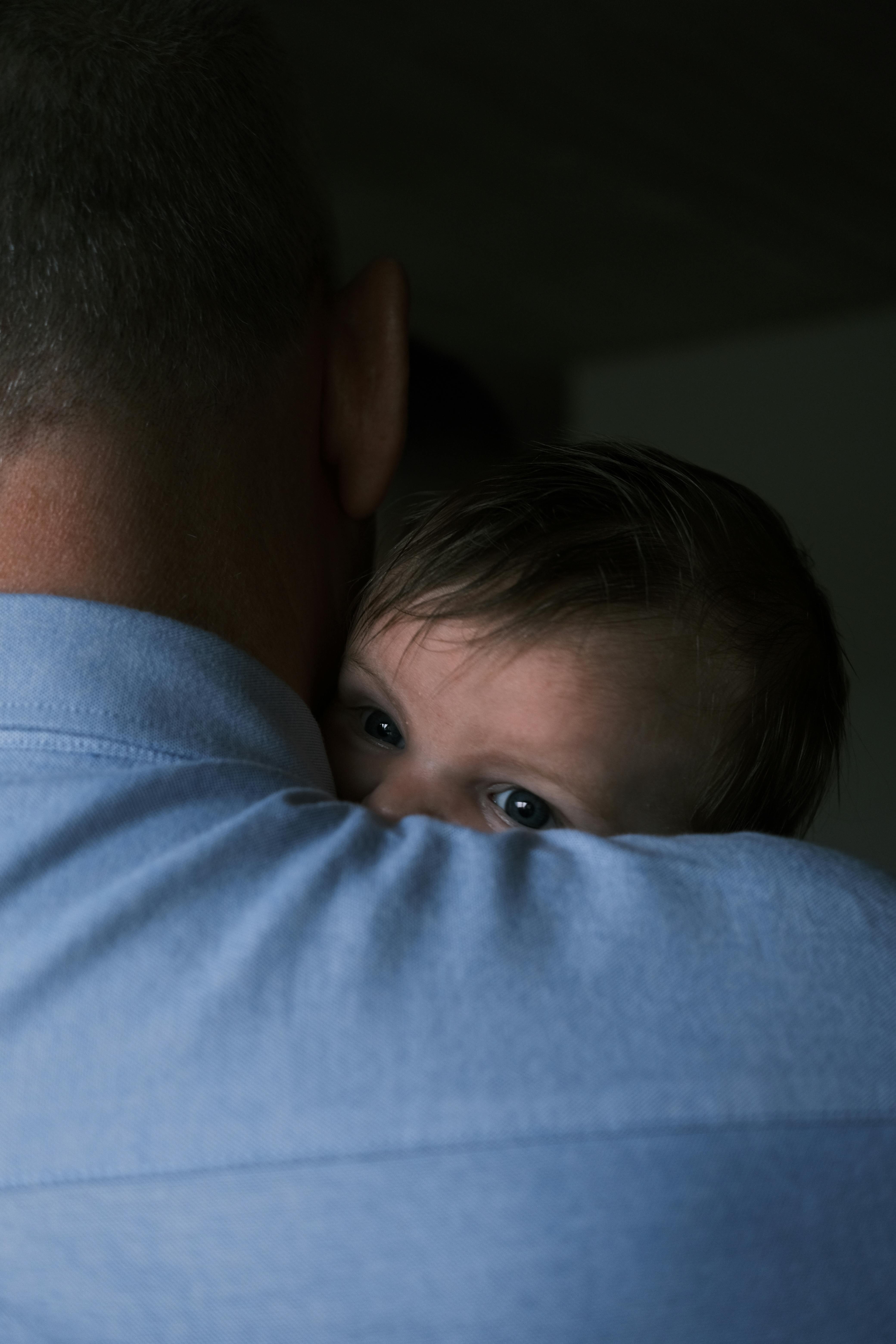 Un padre con su hijo en brazos | Fuente: Pexels
