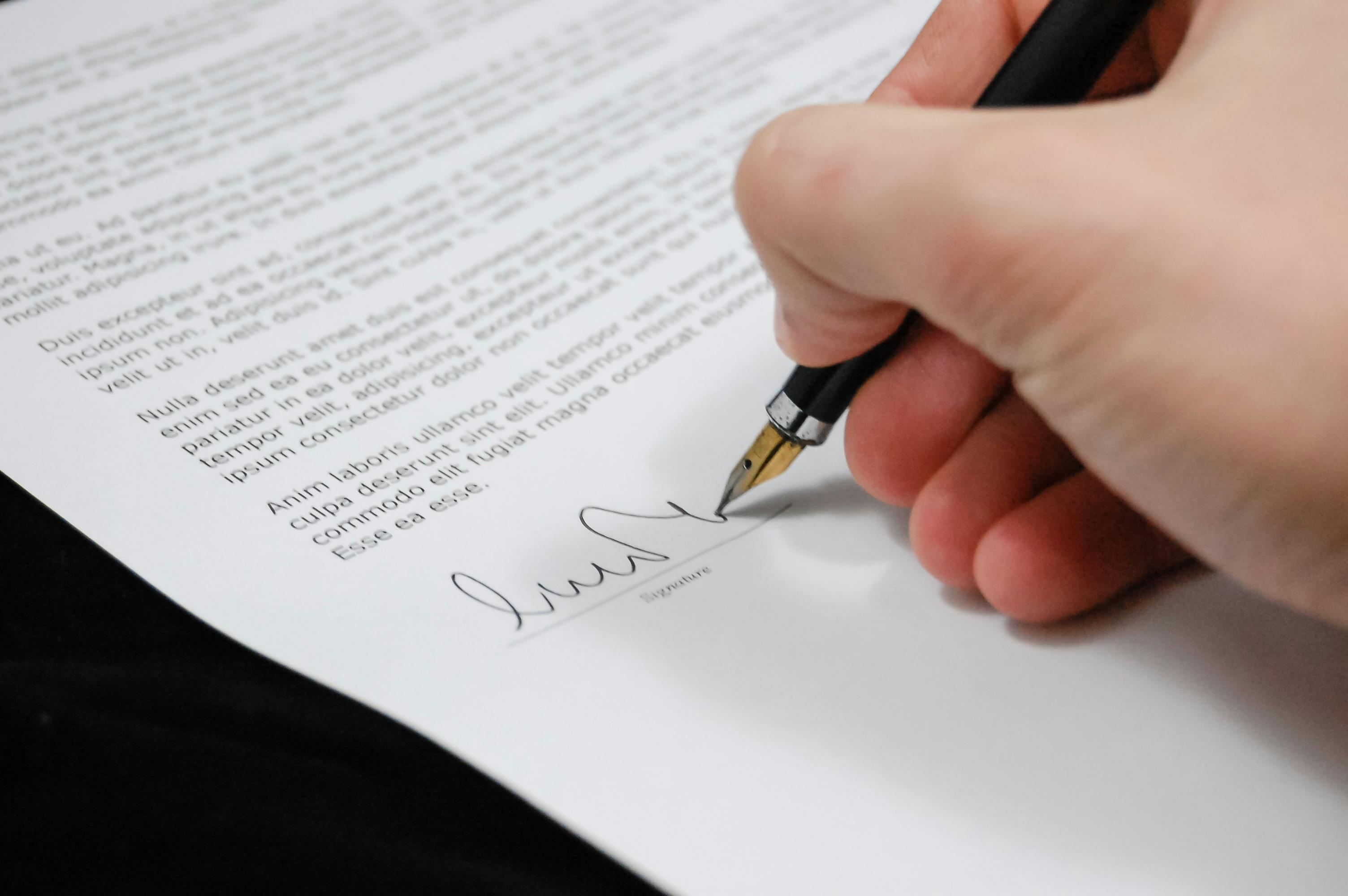 Una persona firmando papeles | Fuente: Pexels