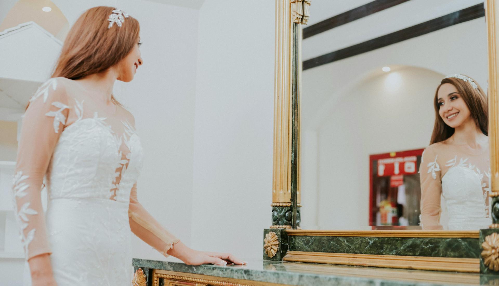 Una novia emocionada admirándose en el espejo | Fuente: Pexels