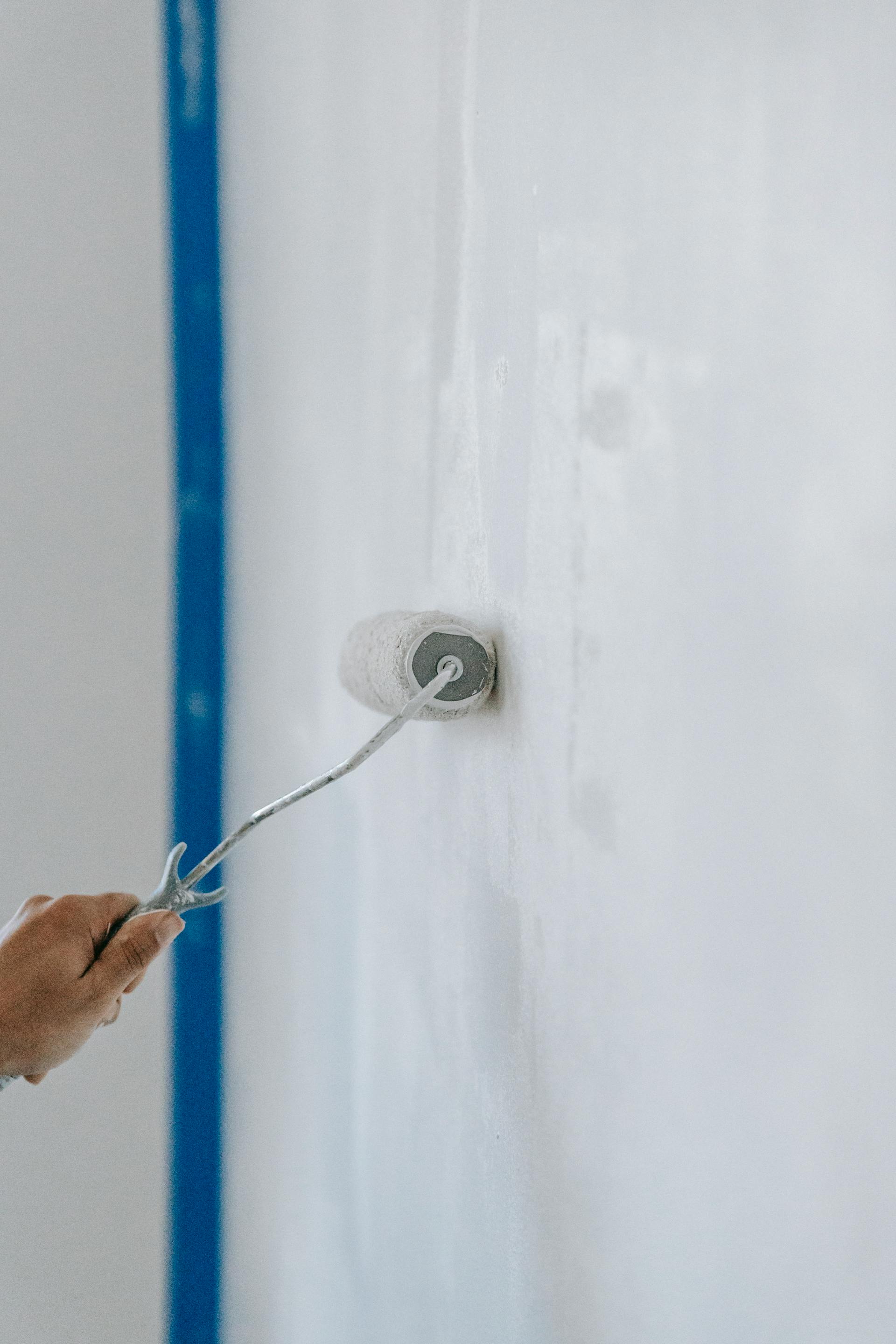 Una persona pintando la pared con un rodillo | Fuente: Pexels