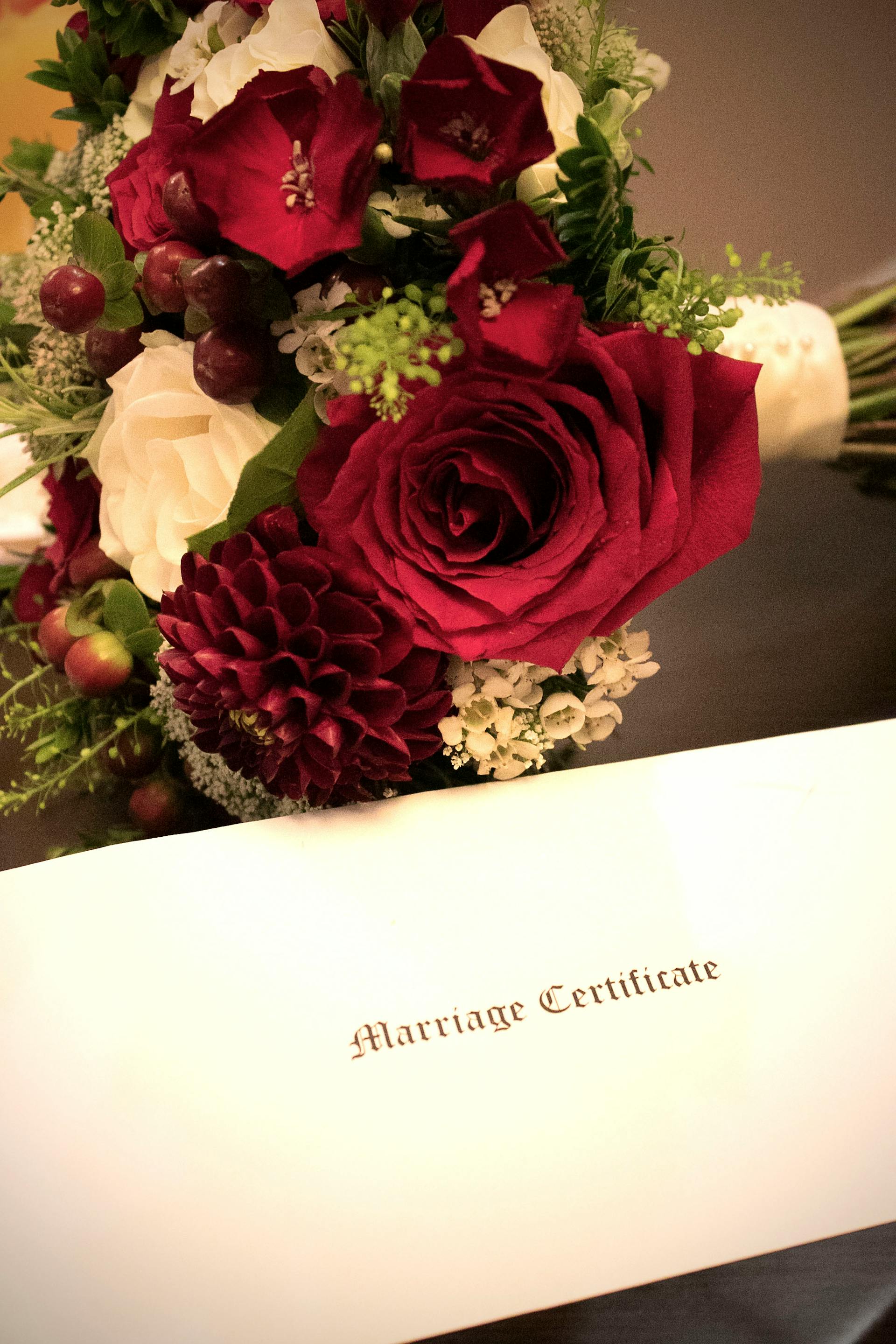 Un ramo junto a un documento de certificado de matrimonio | Fuente: Pexels