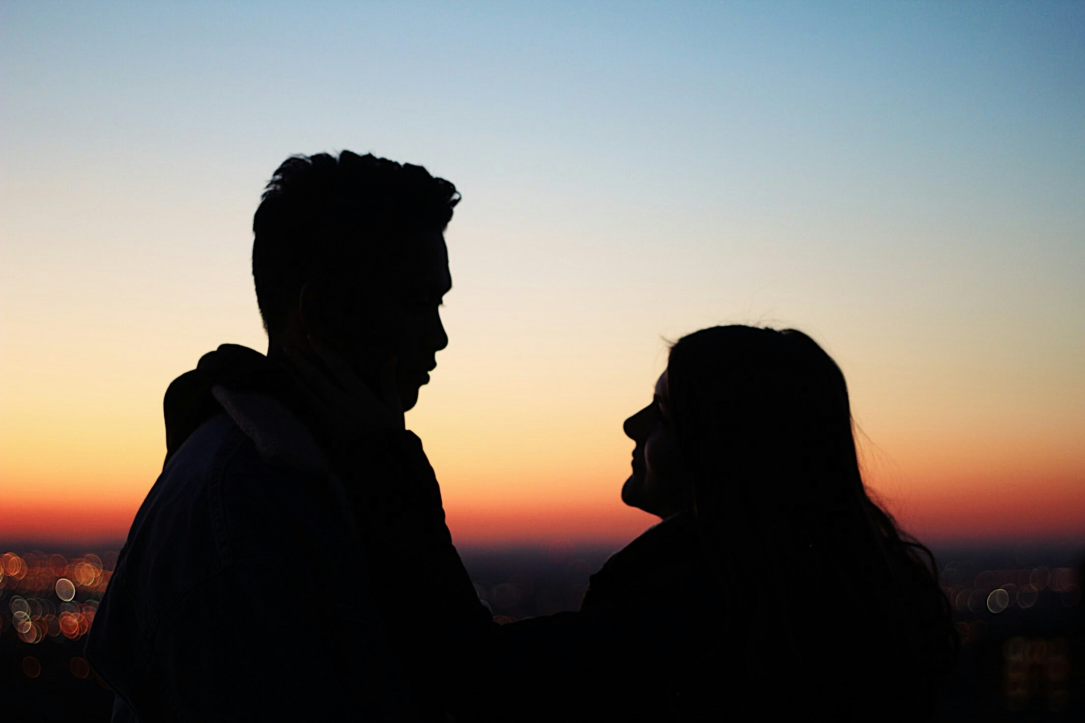 Silueta de un hombre y una mujer hablando | Fuente: Unsplash