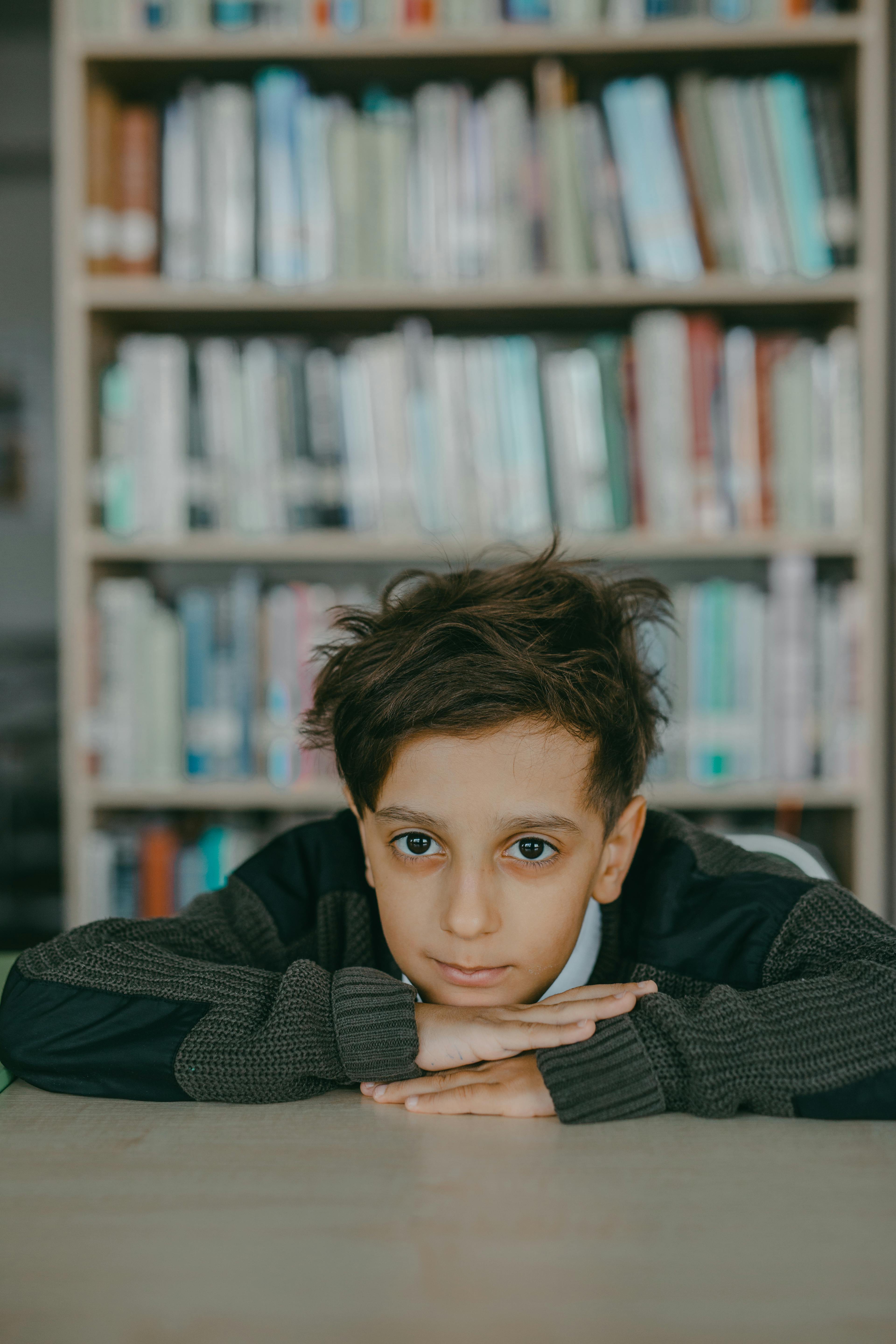 Un niño apoyado en un escritorio | Fuente: Pexels