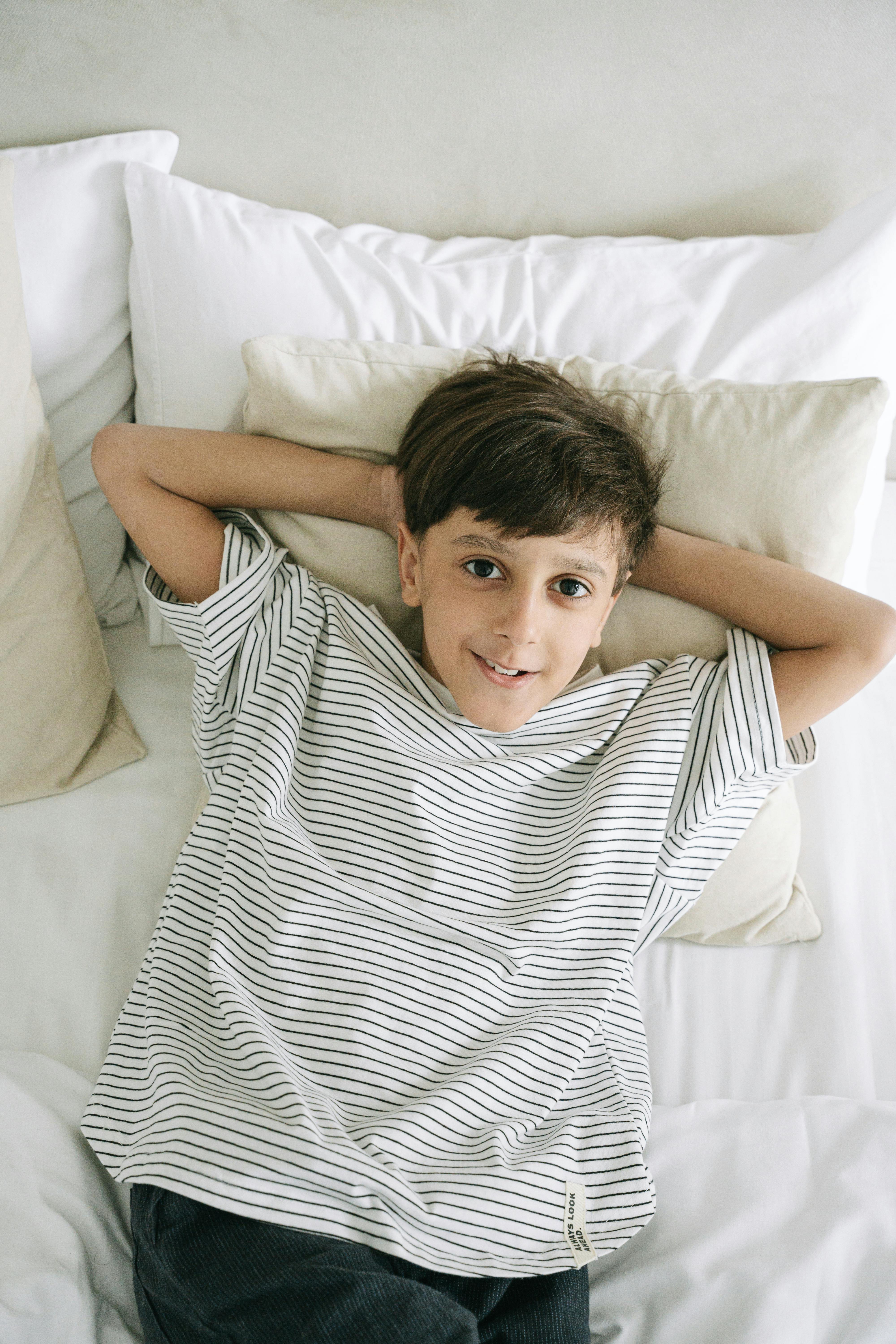 Un niño tumbado en la cama | Fuente: Pexels