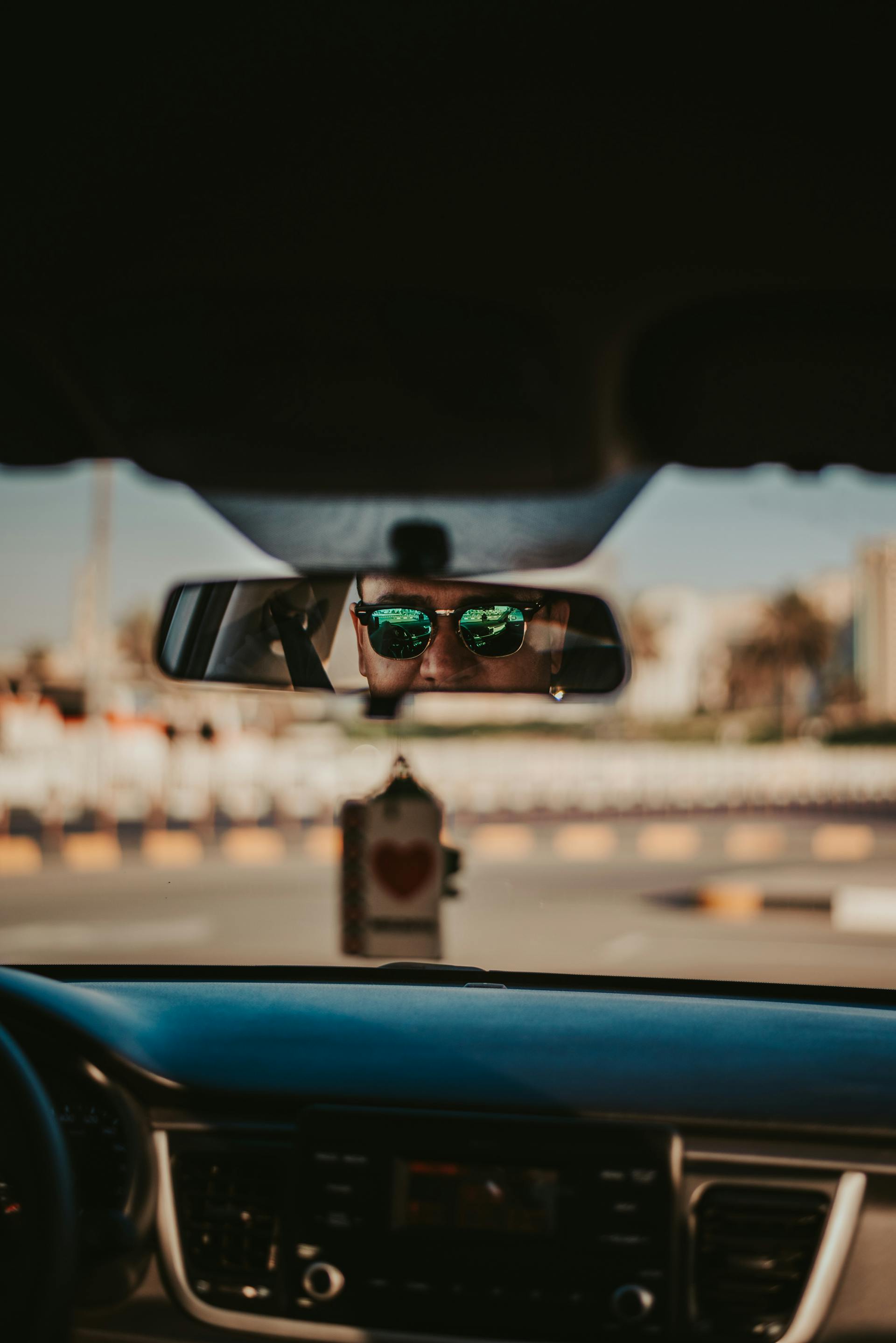 El reflejo de un hombre en un espejo retrovisor | Fuente: Pexels