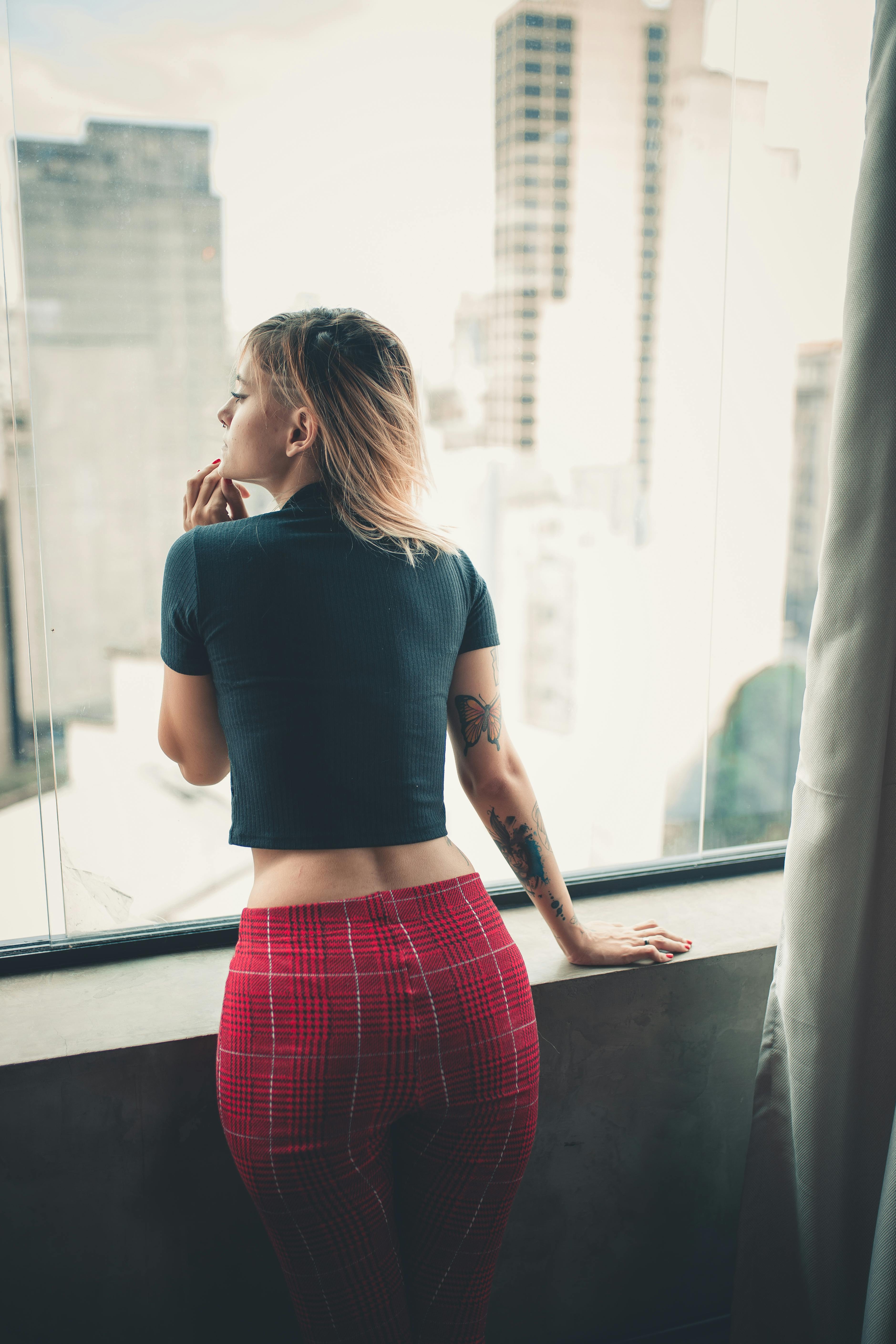 Una mujer mirando por la ventana | Fuente: Pexels