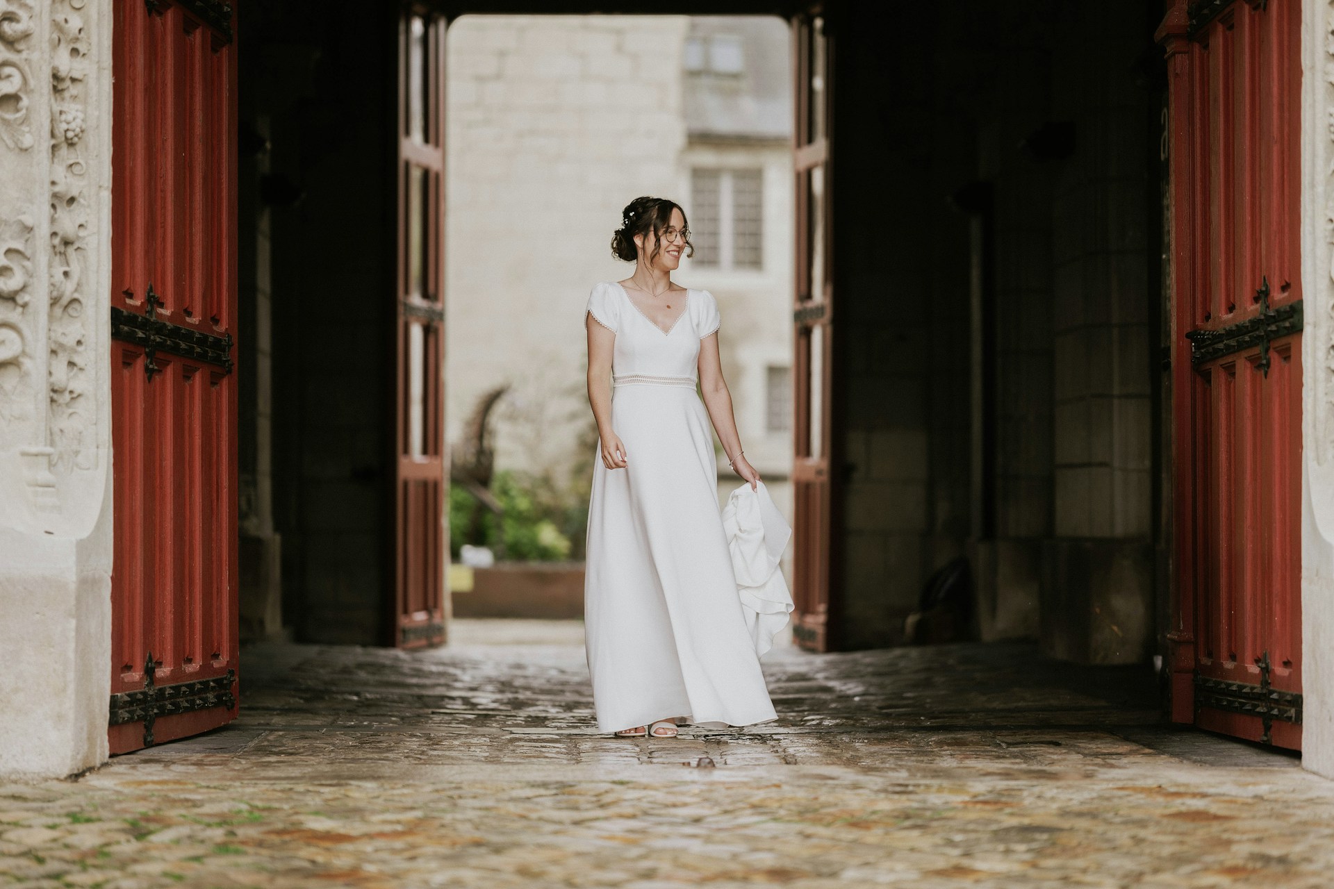Una novia de pie cerca de una puerta sonriendo a alguien | Fuente: Unsplash