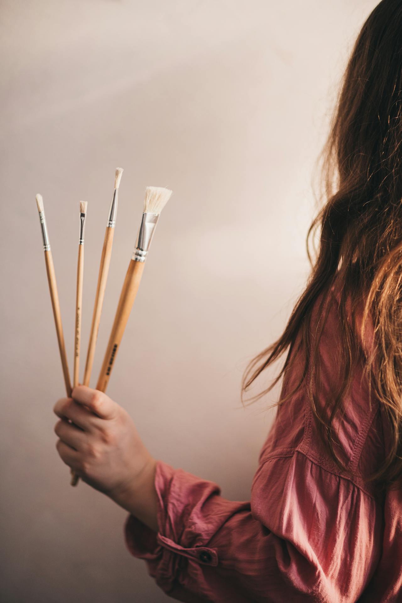 Una mujer sujetando pinceles | Fuente: Pexels