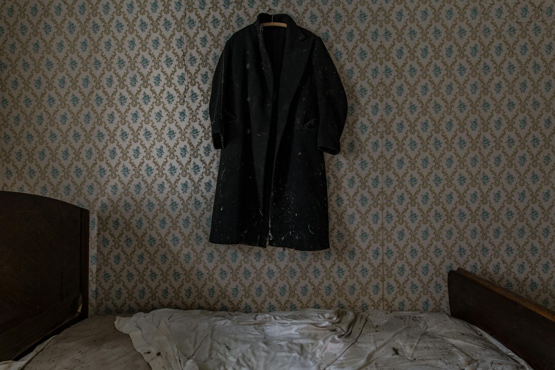 Un colchón de aspecto viejo en una habitación con una chaqueta colgada en la pared | Fuente: Pexels