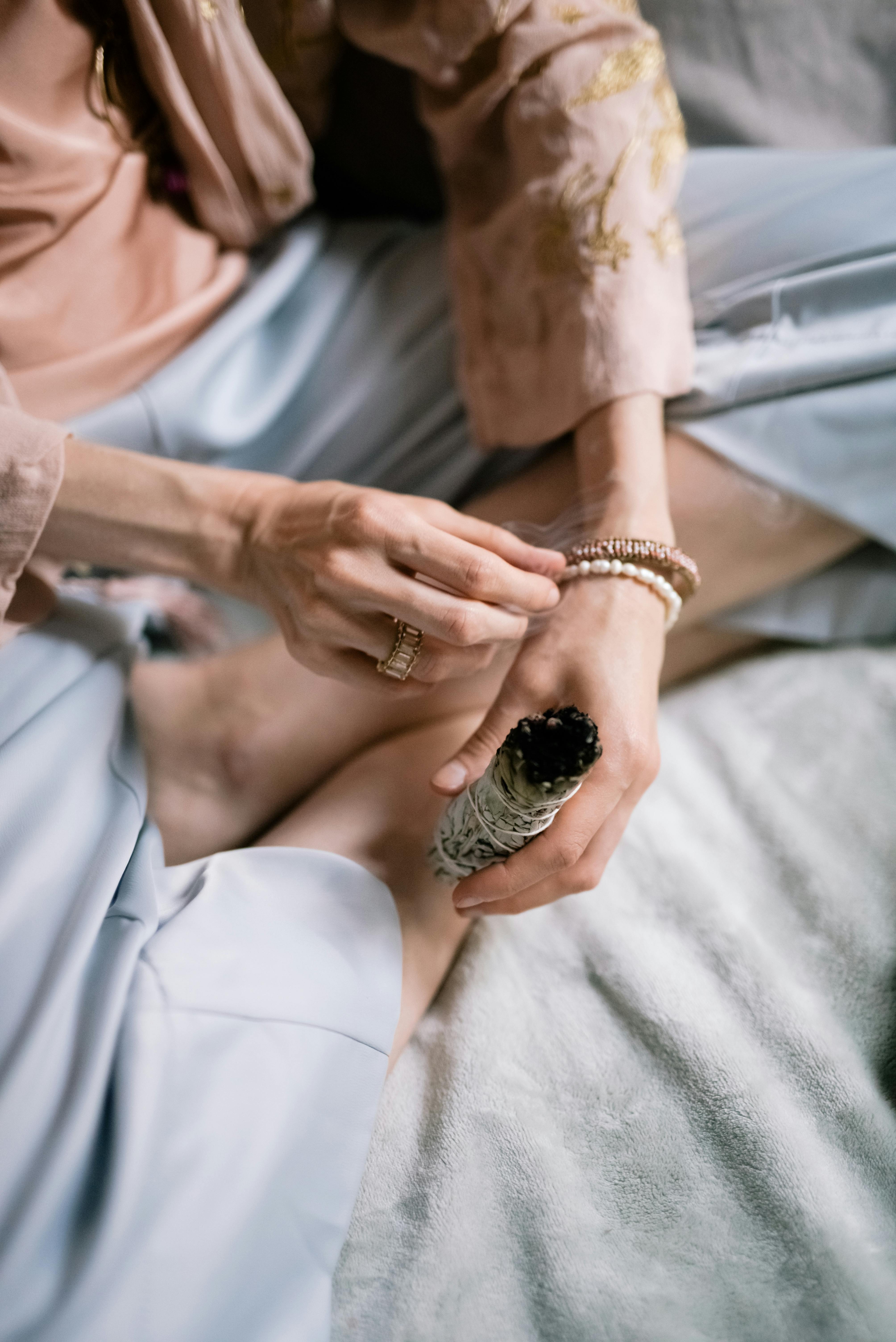 Una mujer quemando hierbas en un dormitorio | Fuente: Pexels