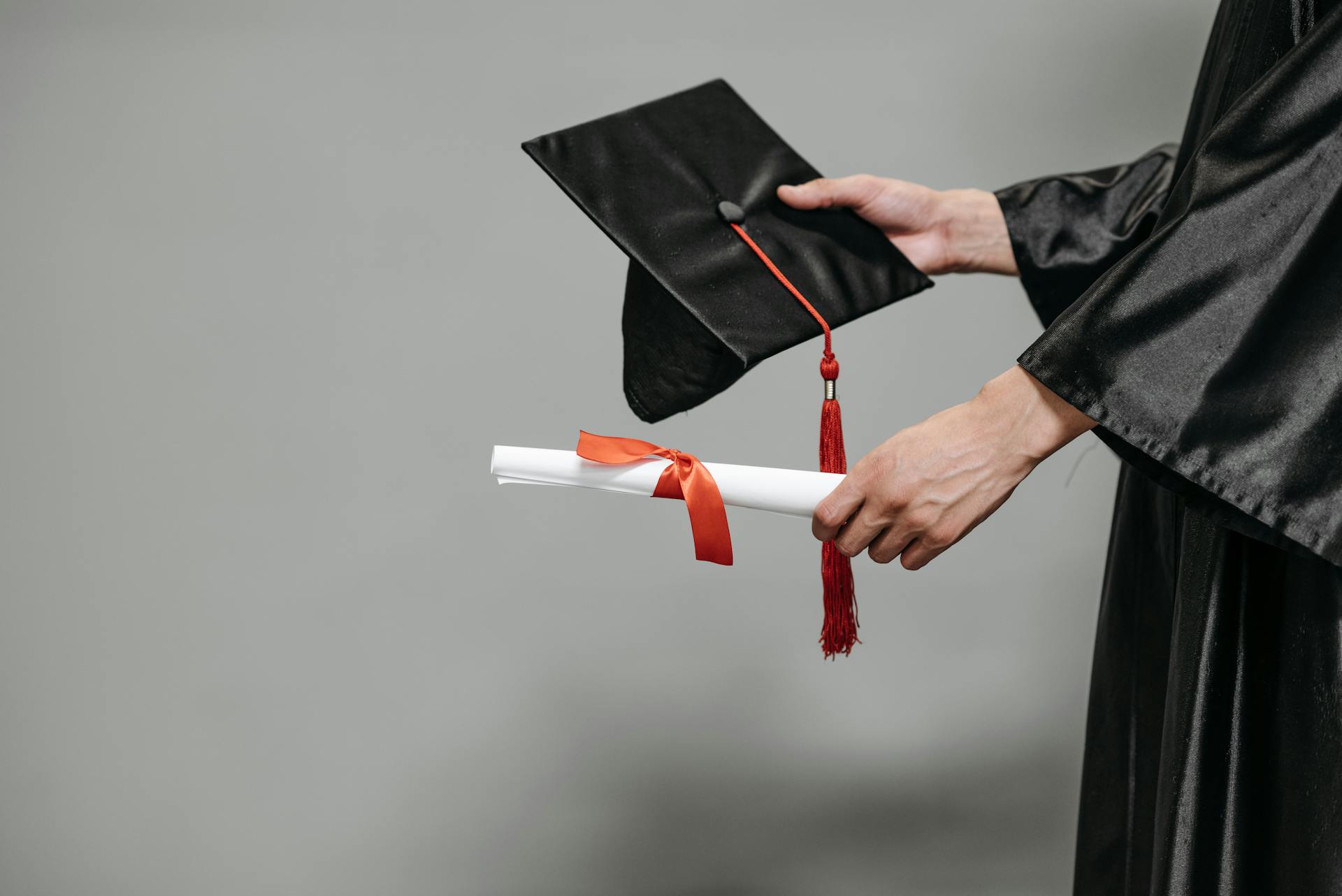 Una persona sujetando su birrete de graduación | Fuente: Pexels