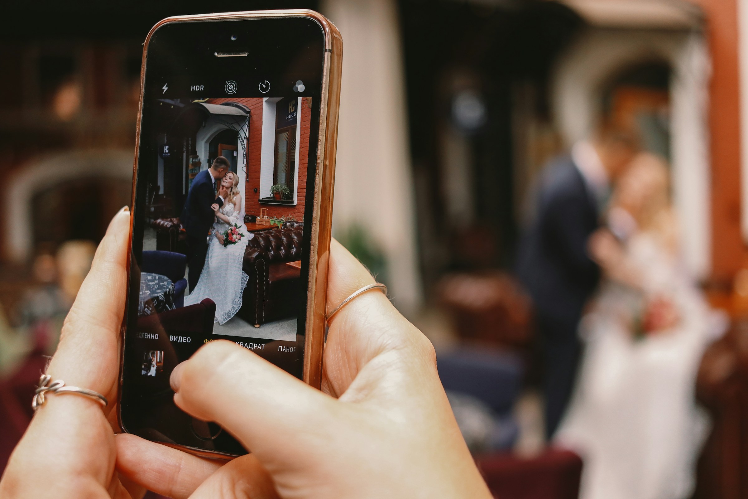 Una persona haciendo clic en una foto de los novios en su teléfono | Fuente: Unsplash