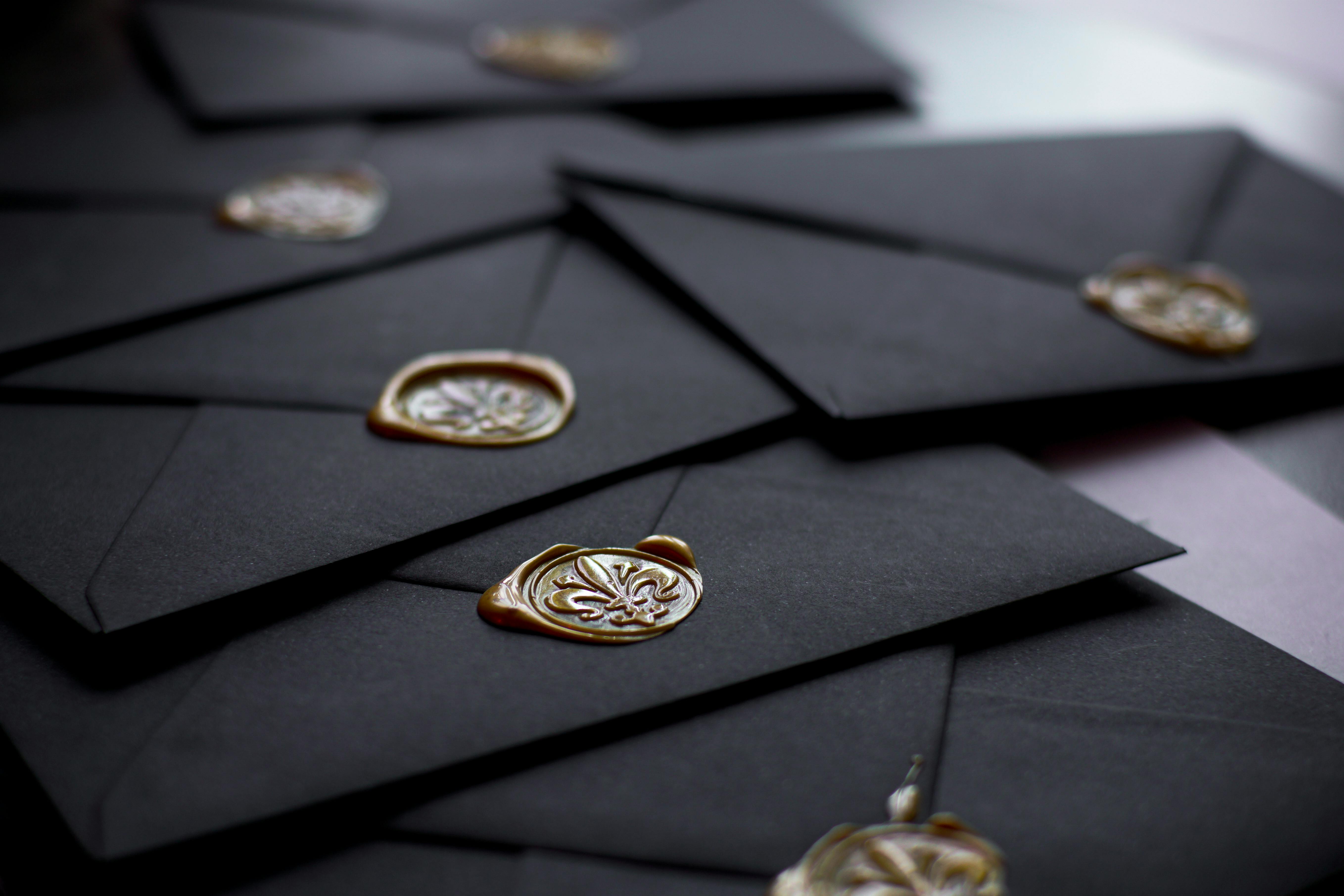Invitaciones de boda negras con sellos de cera | Fuente: Pexels
