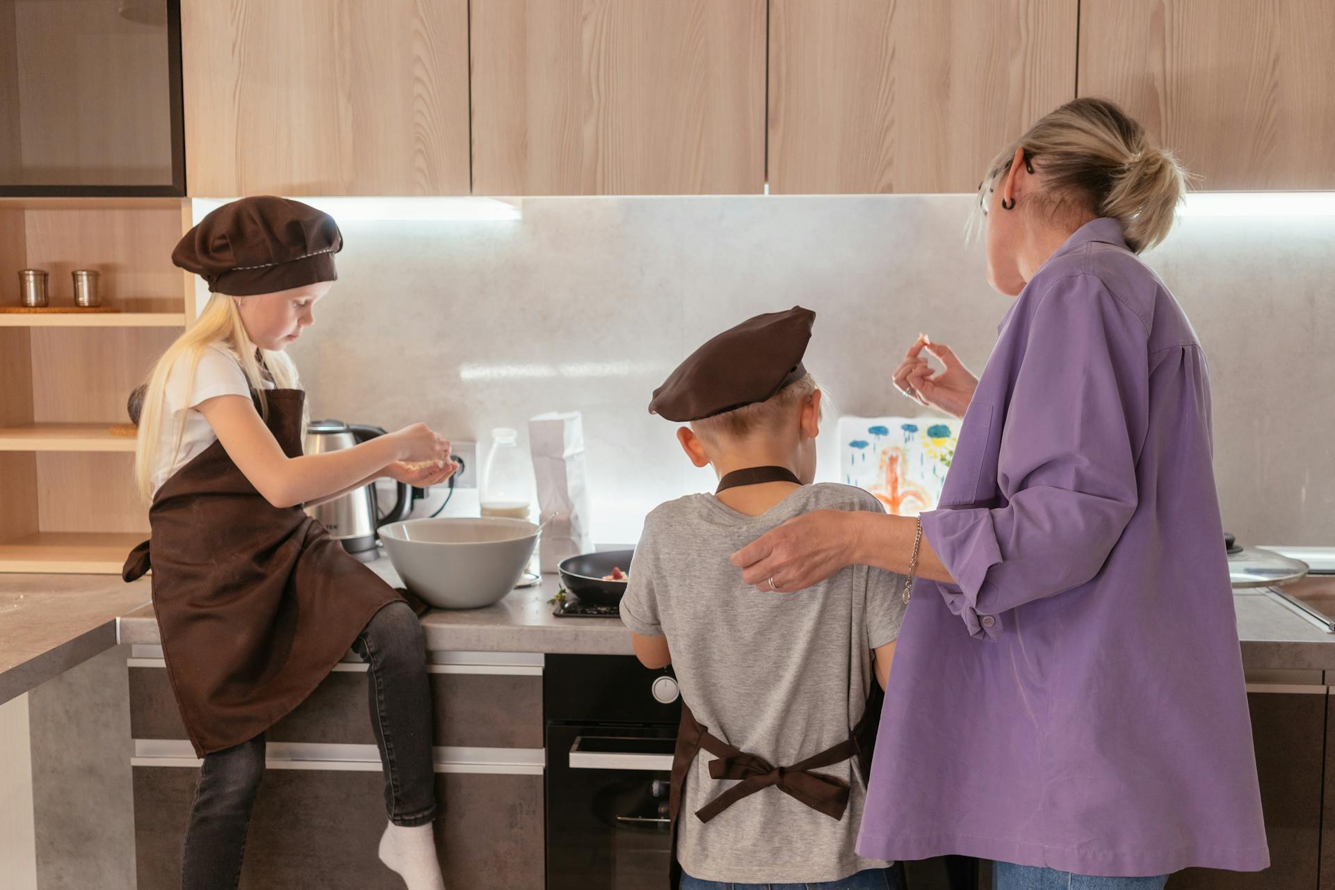 Una abuela junto a sus nietos en la cocina | Fuente: Pexels
