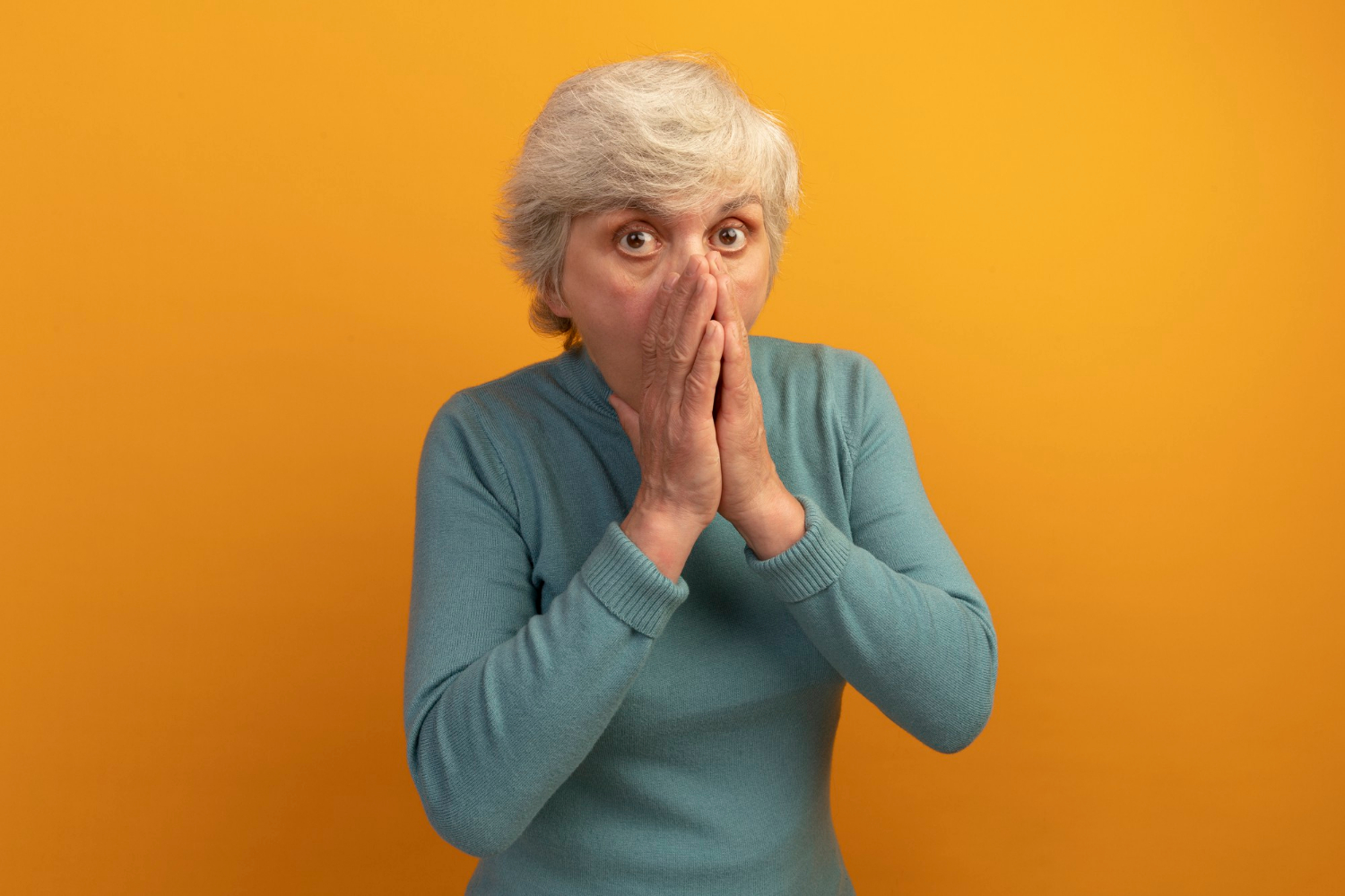 Una anciana conmocionada tapándose la boca | Fuente: Freepik