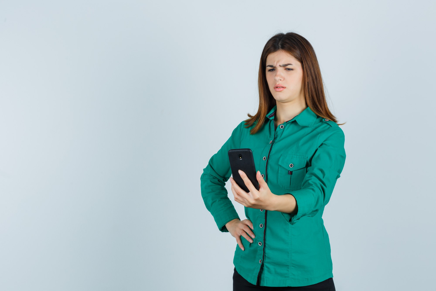 Una mujer aturdida mirando su teléfono | Fuente: Freepik