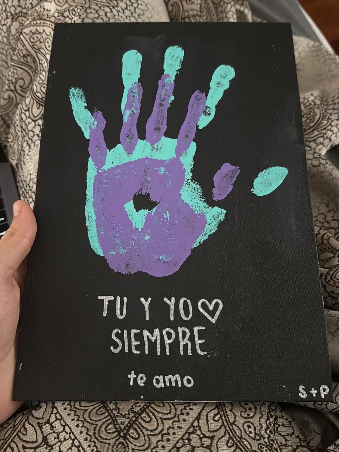 Dos manos impresas en una hoja firmada con las iniciales "S" y "P" | Fuente: Instagram.com/santiagorulligalliano