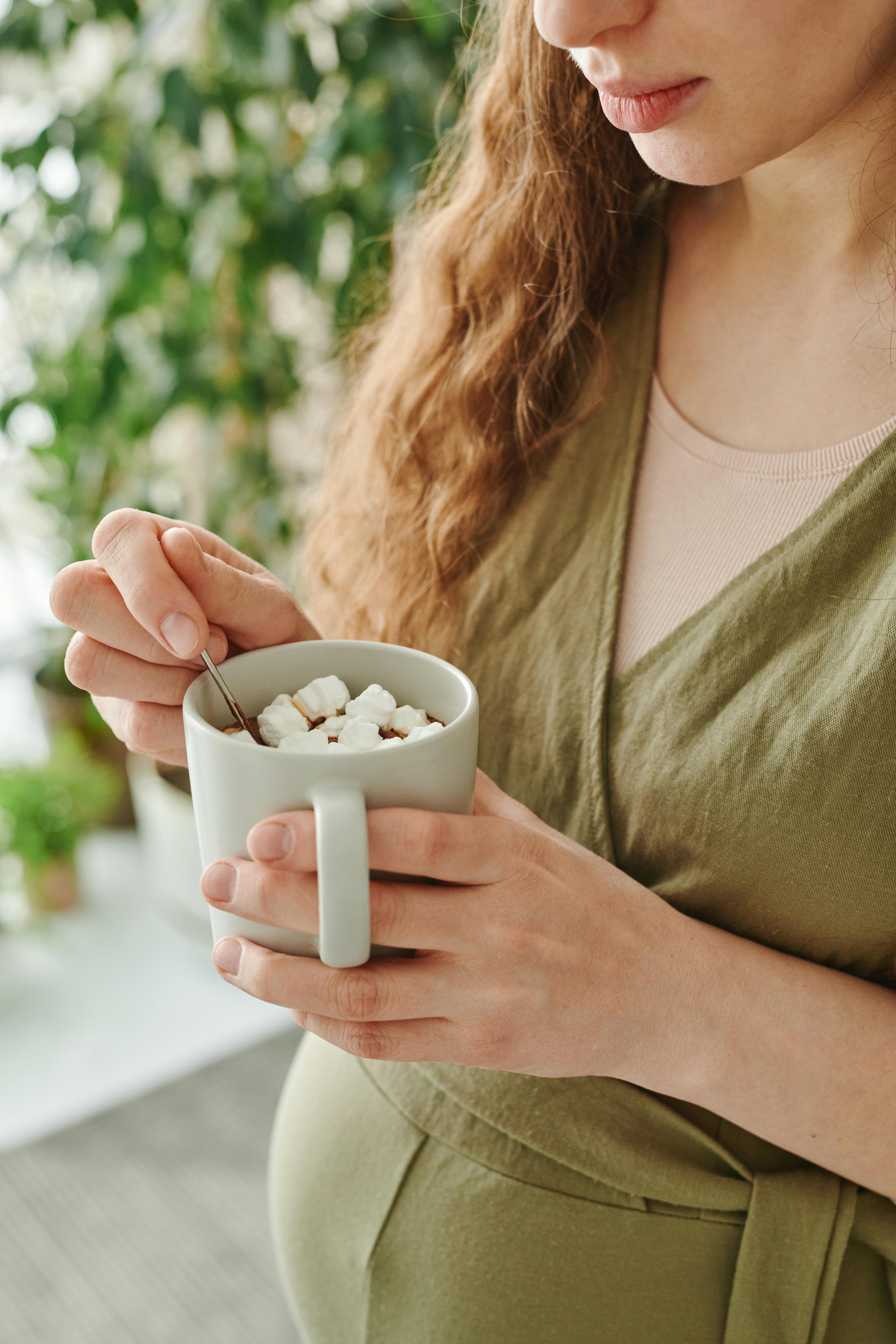 Una mujer con una taza de chocolate caliente en la mano | Fuente: Pexels