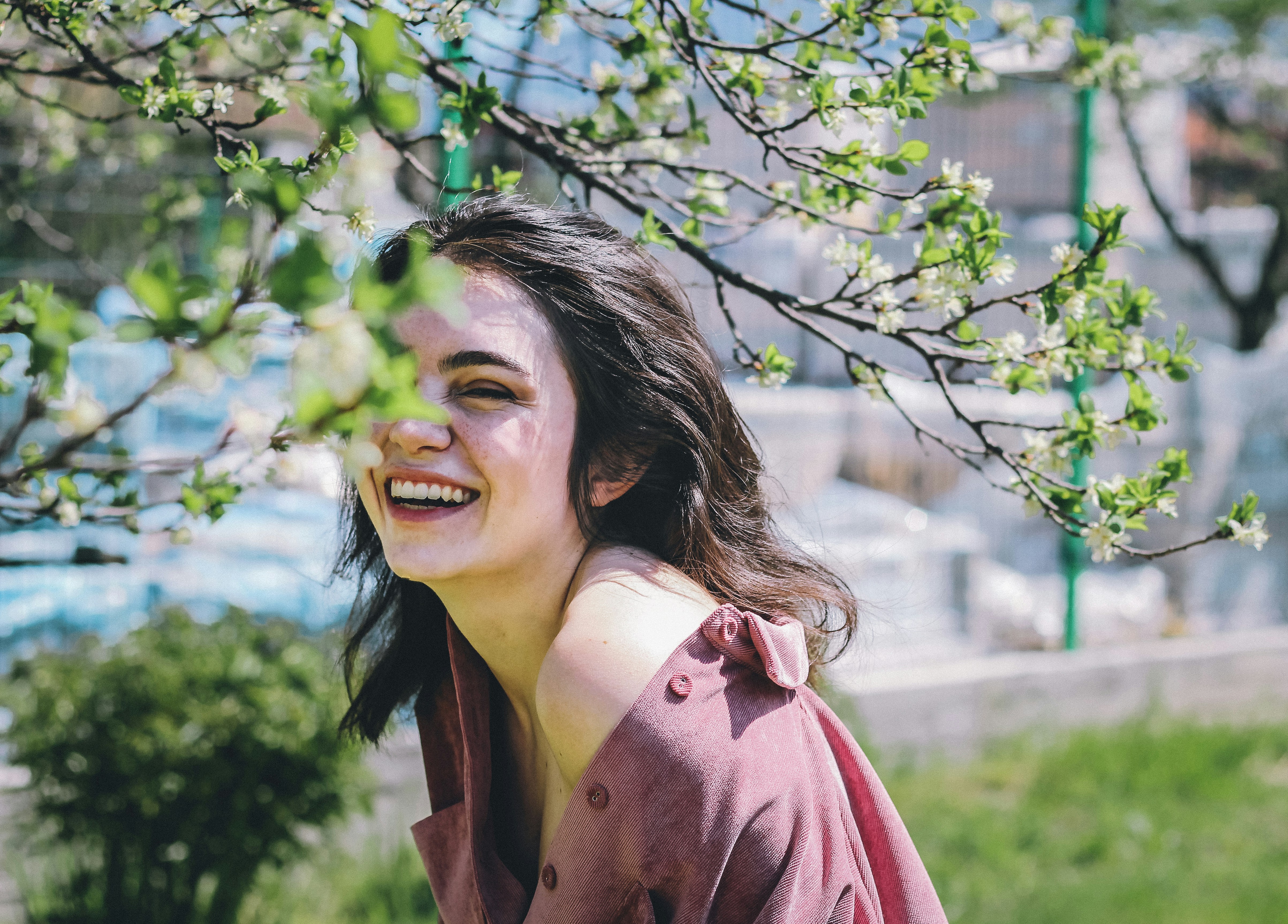 Una joven sonriente de pie en el exterior | Fuente: Unsplash