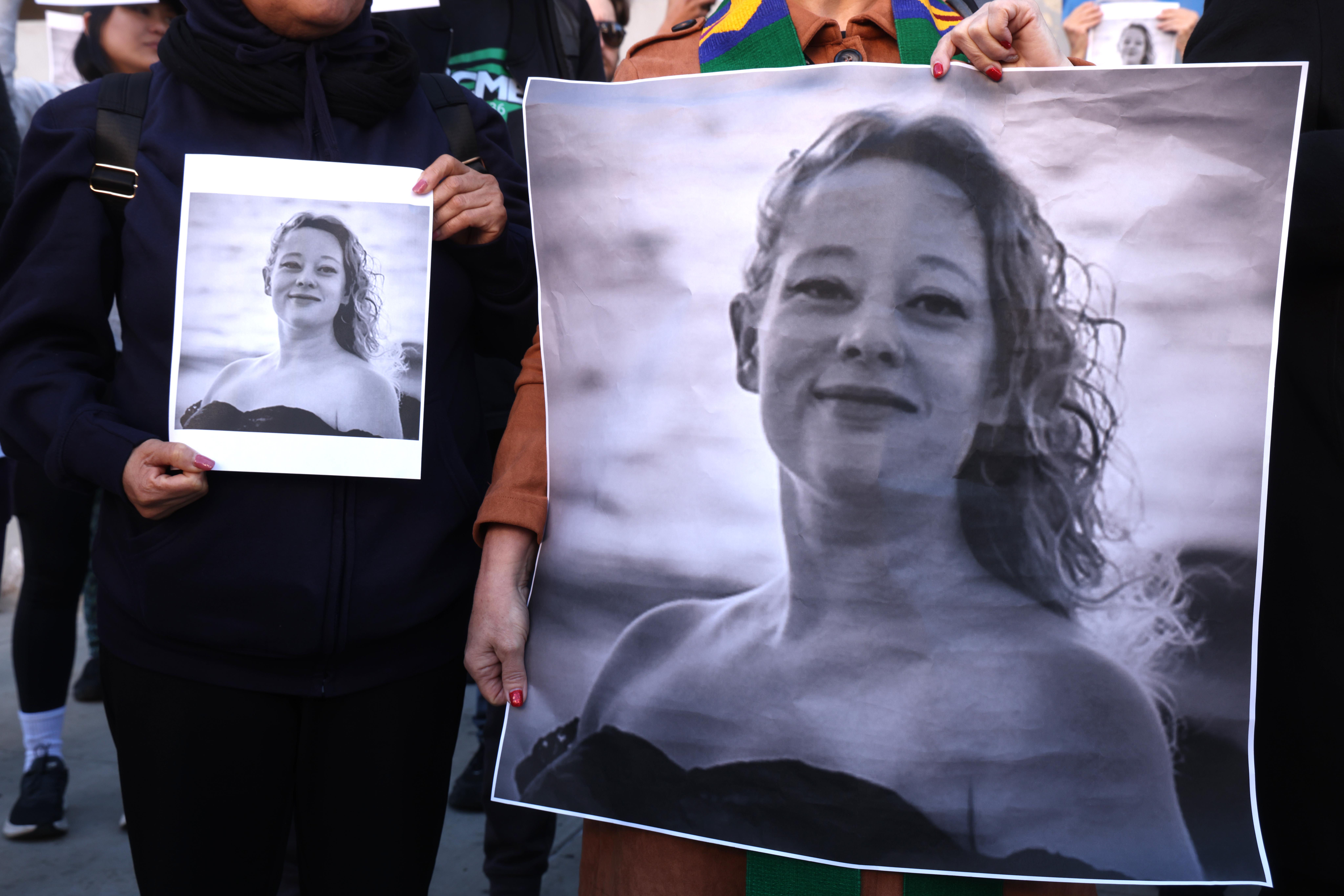 Decenas de personas, sosteniendo fotos de Renee Nicole Good, protestan por su muerte en Minneapolis, en el centro de Los Ángeles, el 8 de enero de 2026. | Fuente: Getty Images