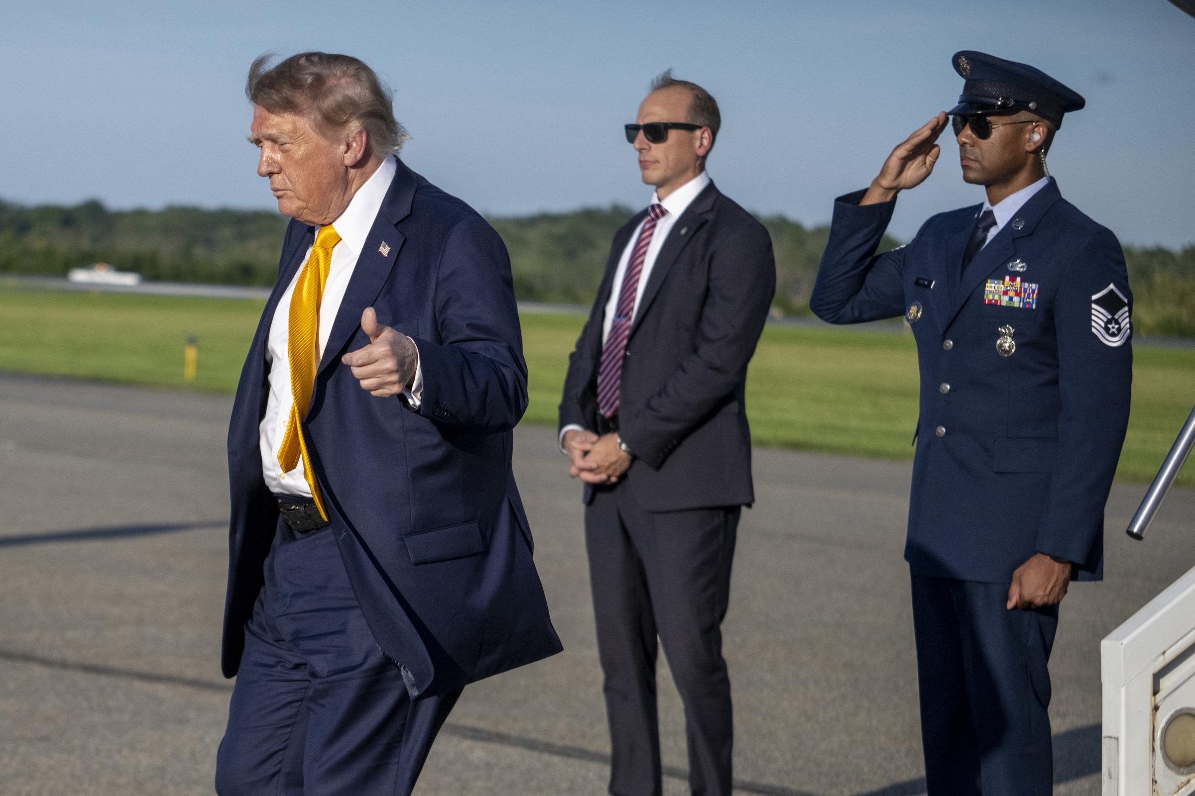 El presidente levanta el pulgar en señal de aprobación mientras se dirige a pasar el fin de semana en su club de golf de Bedminster, y la luz del atardecer resalta el cambio radical en el color de su pelo.