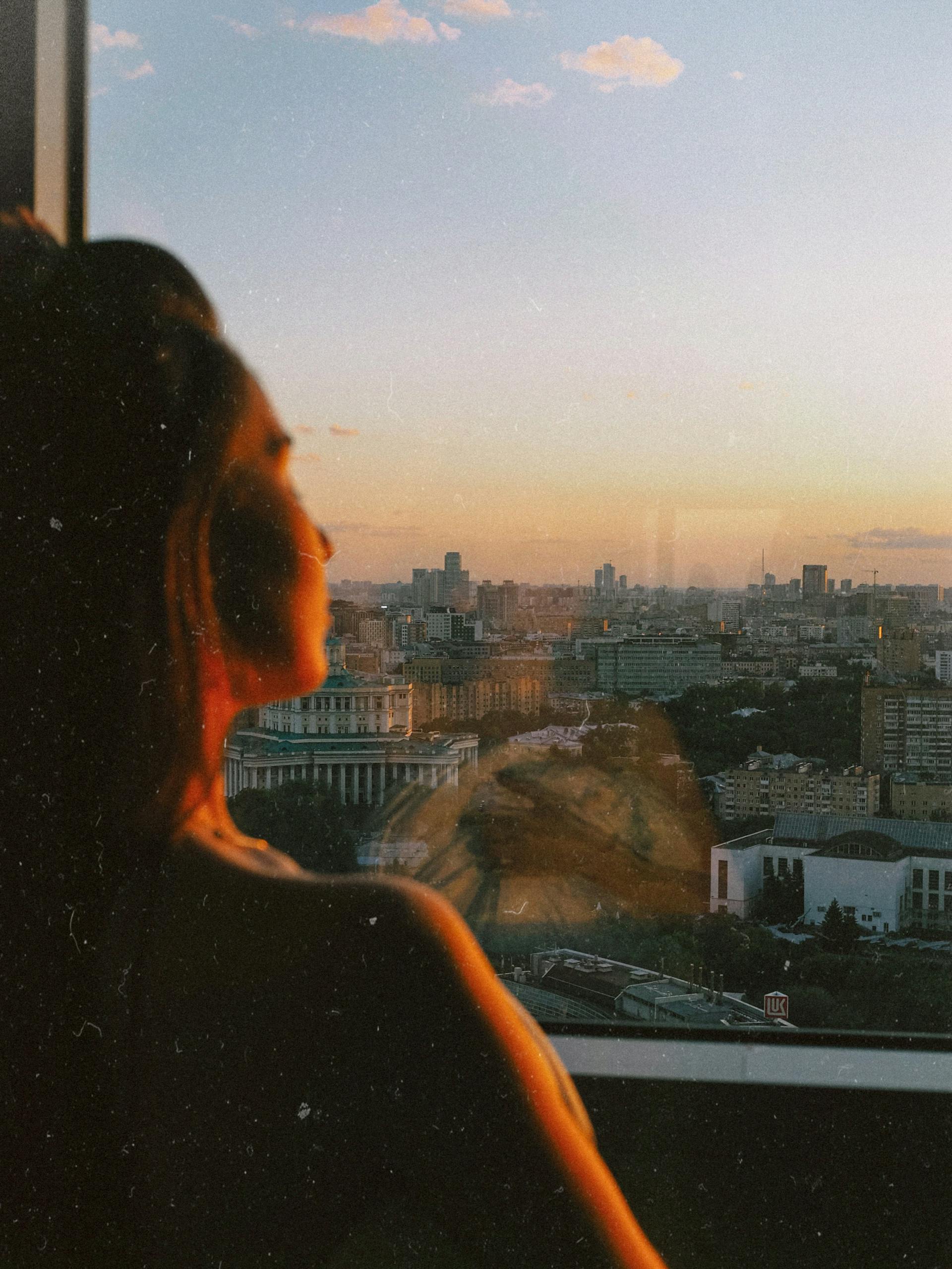 Una mujer mirando por la ventana | Fuente: Pexels
