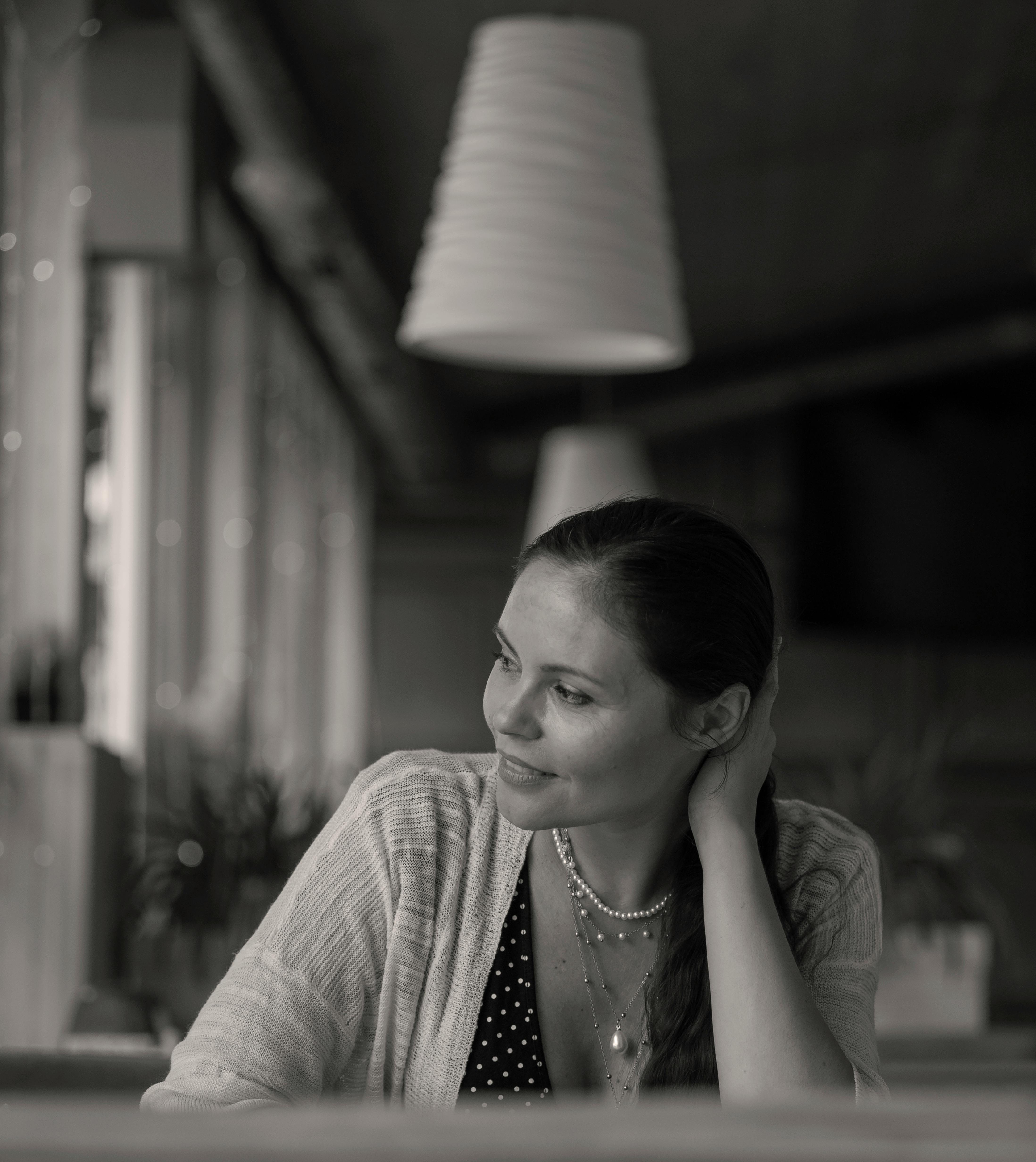 Foto en escala de grises de una mujer sentada en un restaurante | Fuente: Pexels