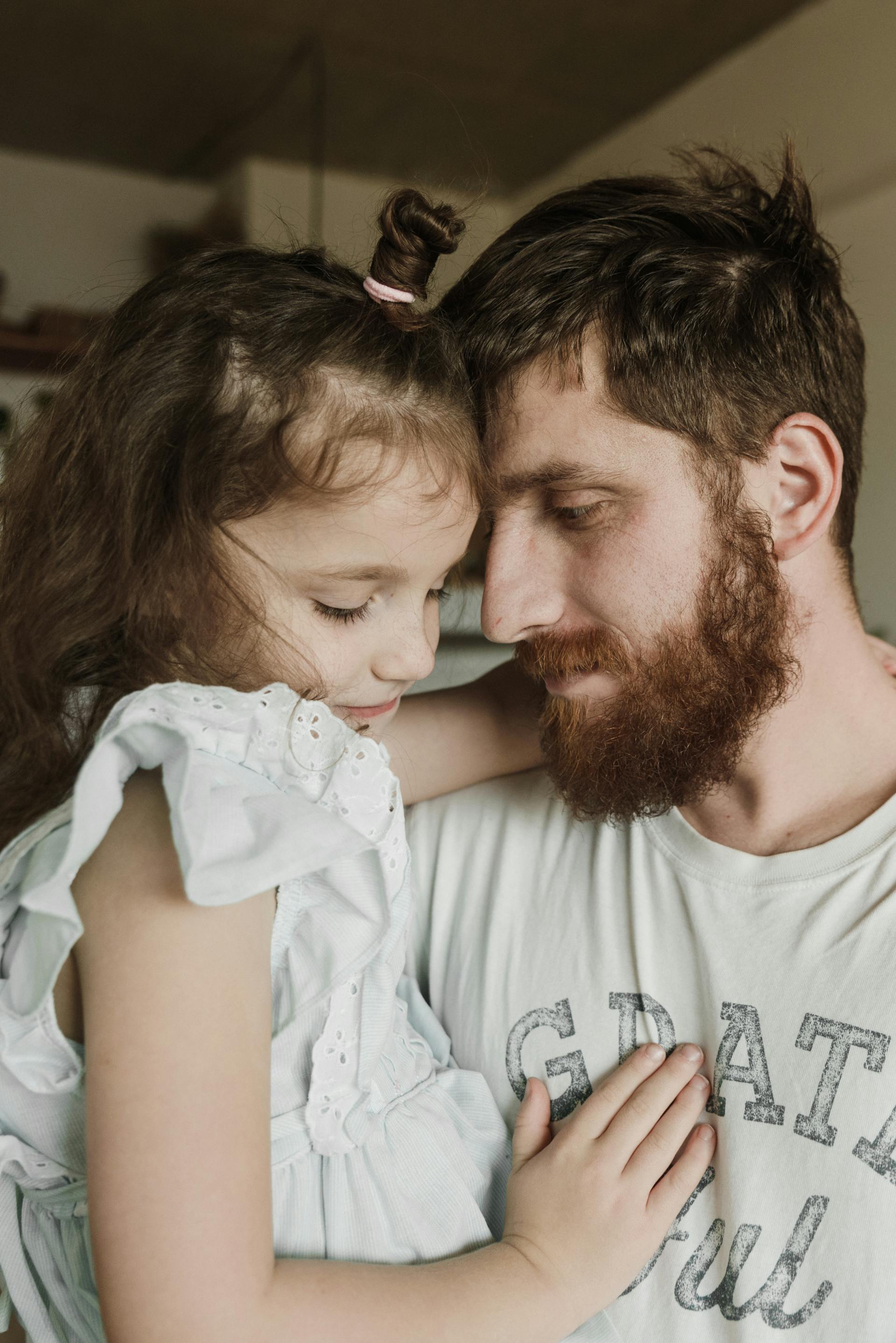 Un padre con su hija pequeña en brazos | Fuente: Pexels