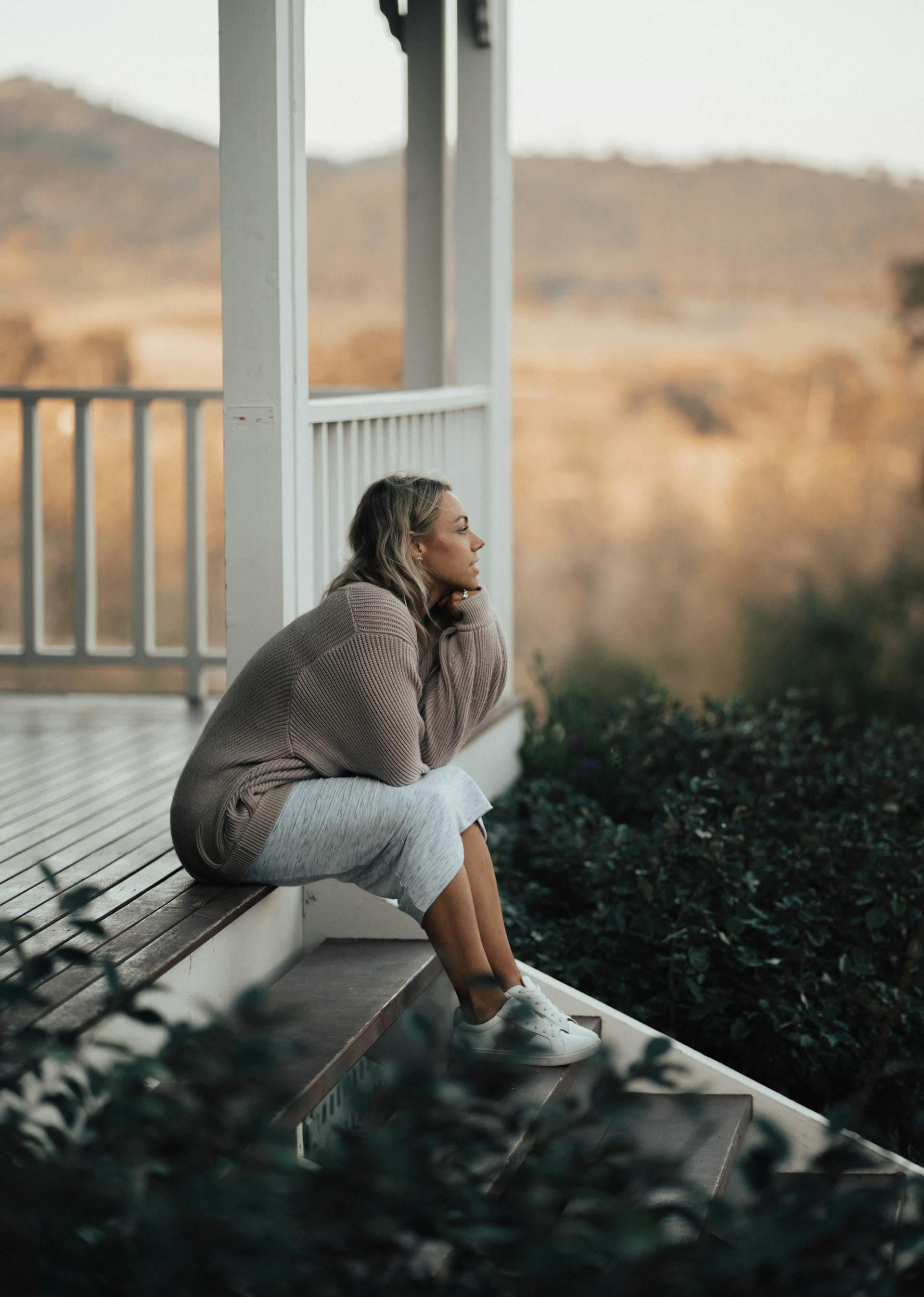 Una mujer sentada en un porche | Fuente: Pexels