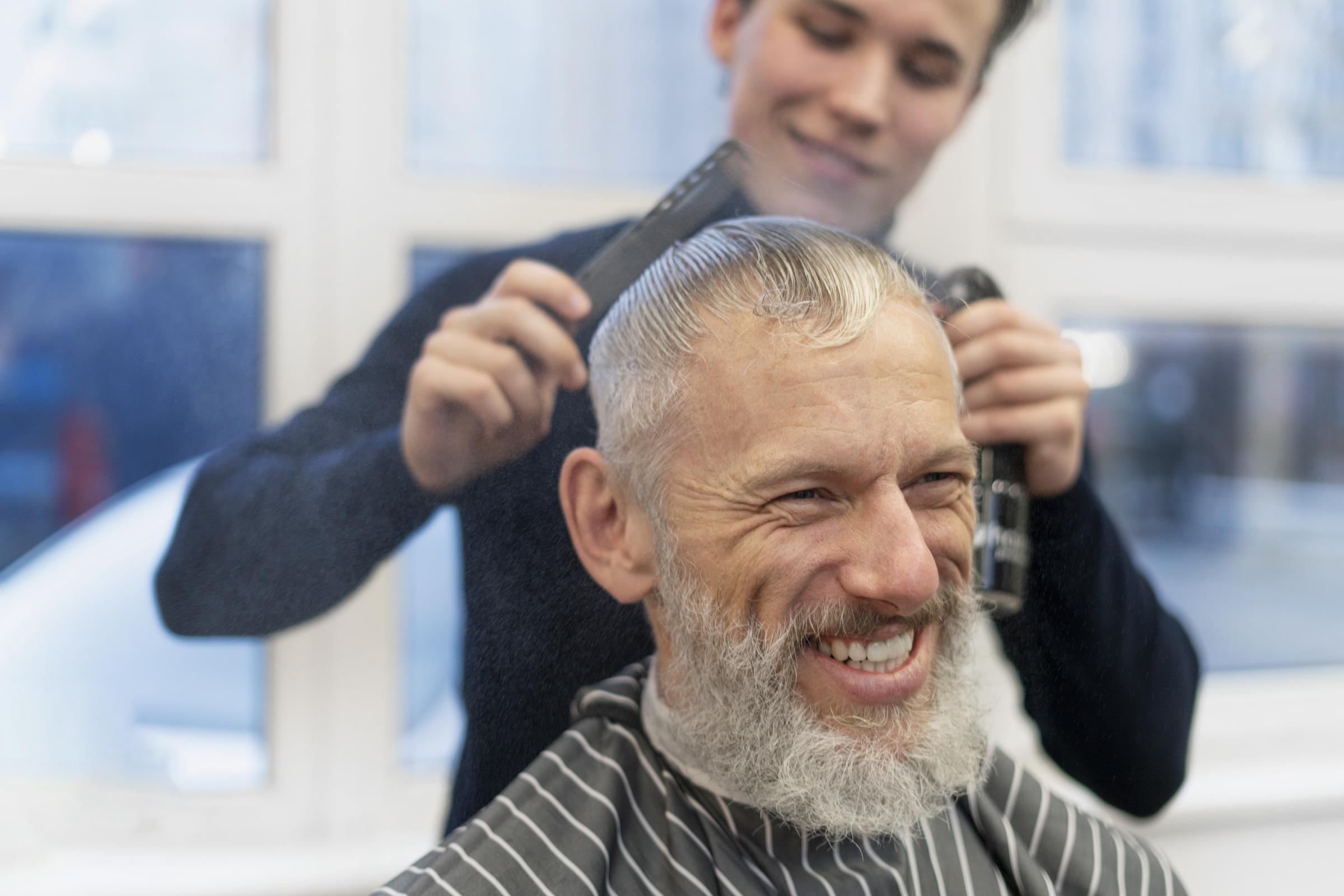 Un hombre sonriente en una peluquería | Fuente: Freepik