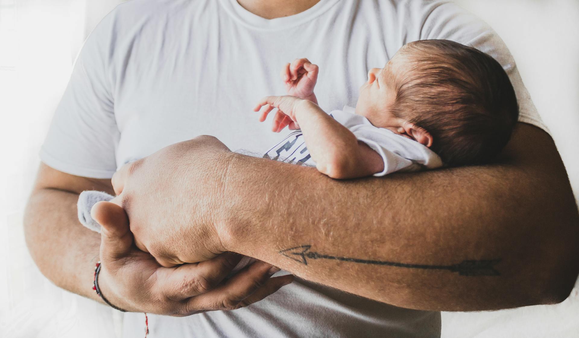 Un hombre con un bebé en brazos | Fuente: Pexels
