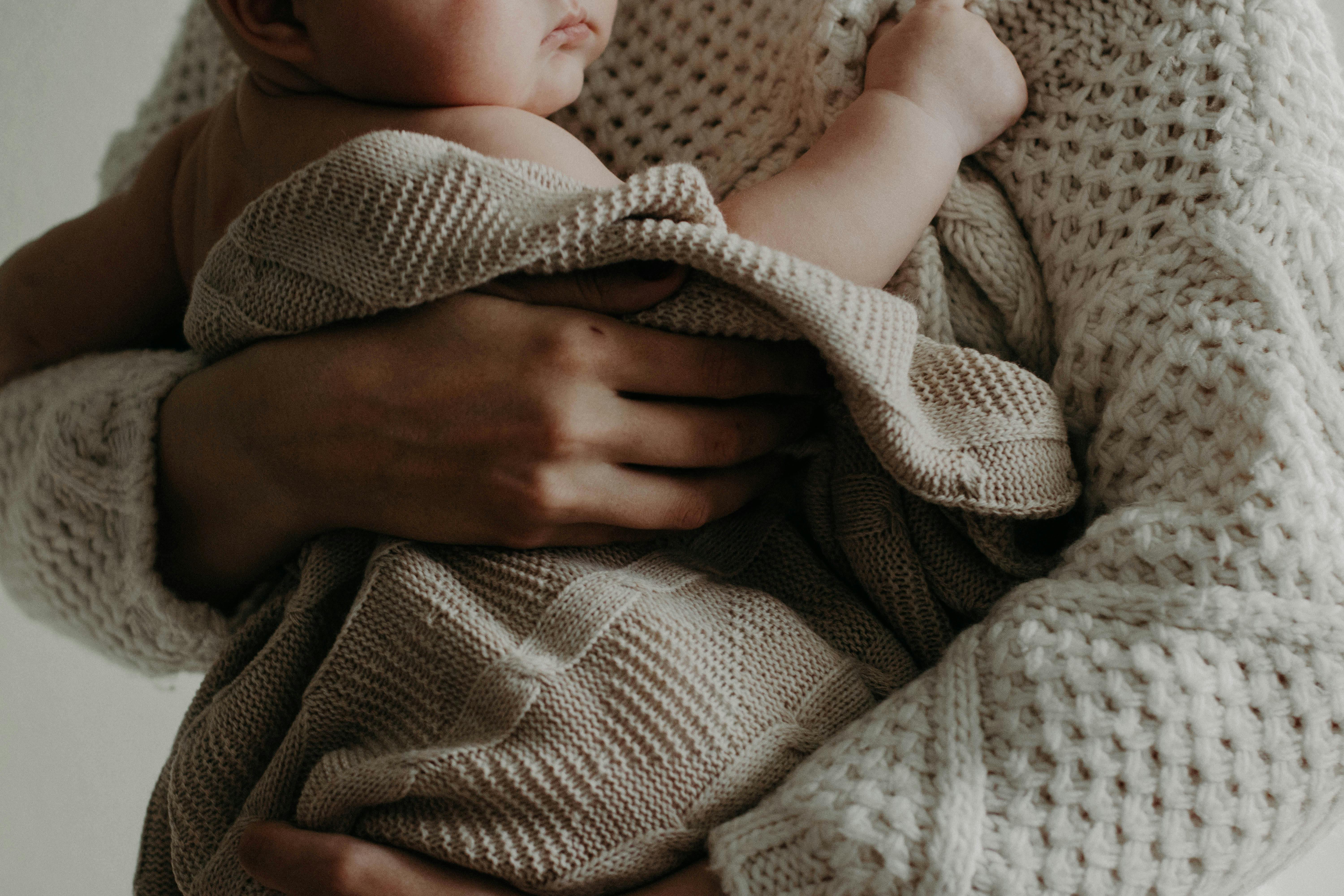 Una mujer con un bebé en brazos | Fuente: Pexels