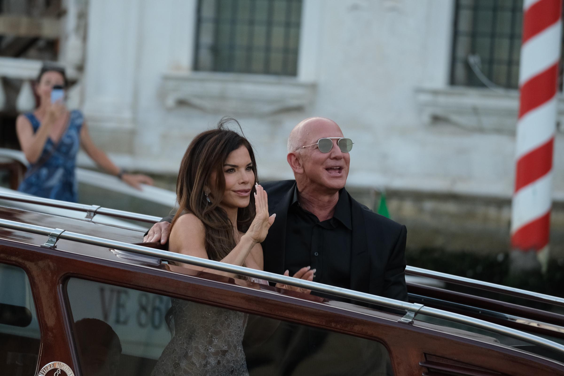 Lauren Sánchez y Jeff Bezos saludan a los curiosos desde un barco durante la celebración de su boda | Fuente: Getty Images