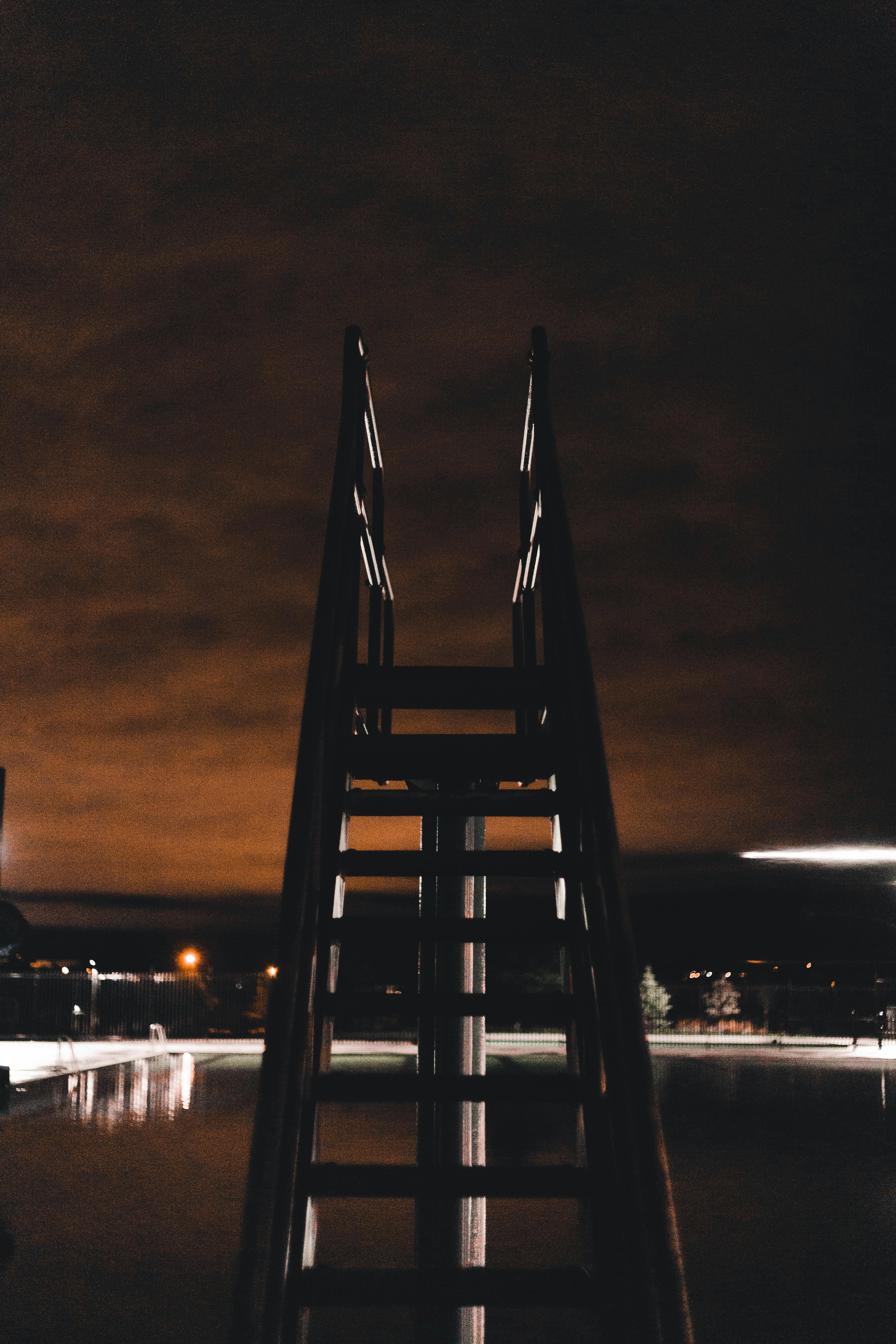 Un trampolín en una piscina de noche | Fuente: Pexels