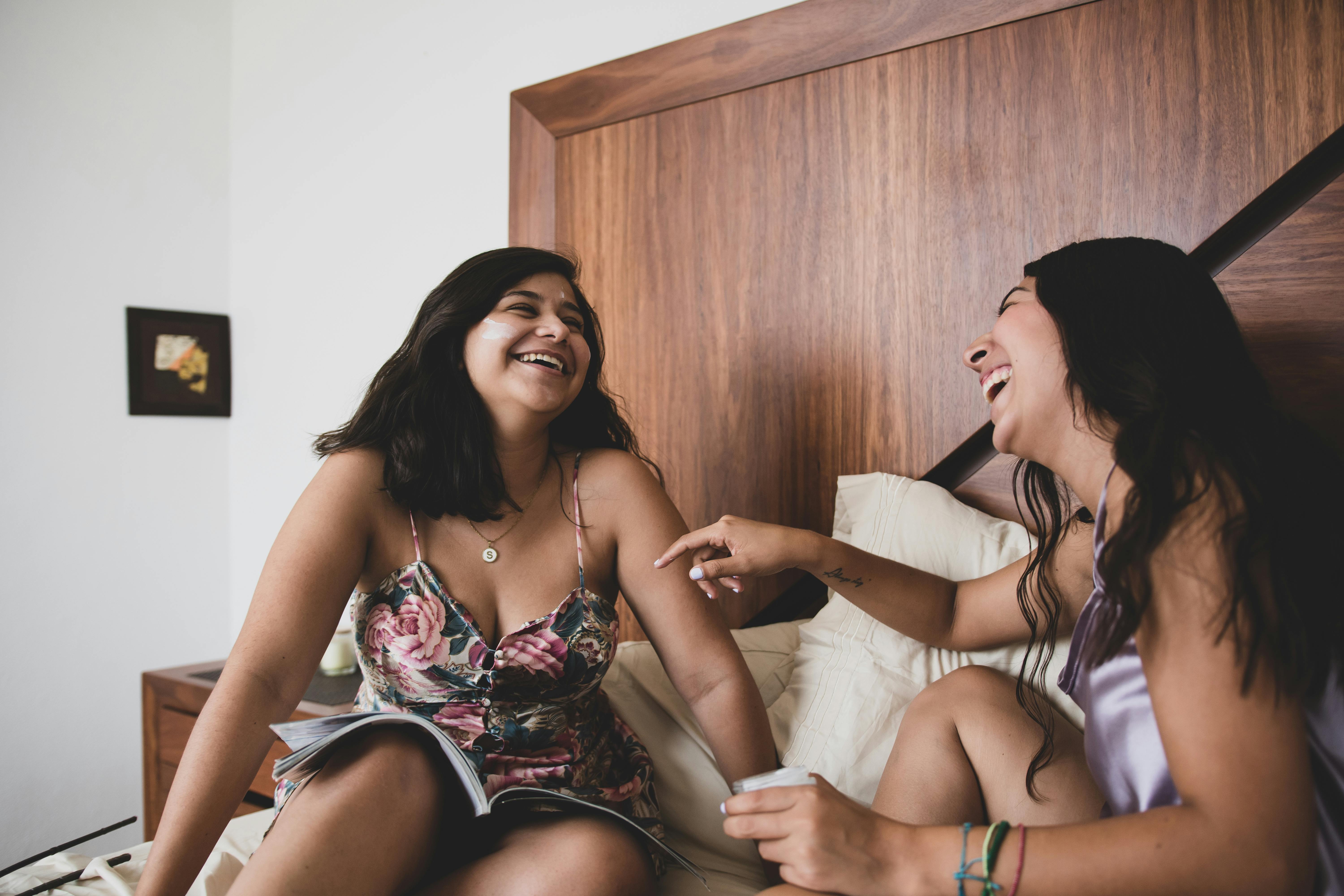 Dos mujeres riendo en la cama | Fuente: Pexels