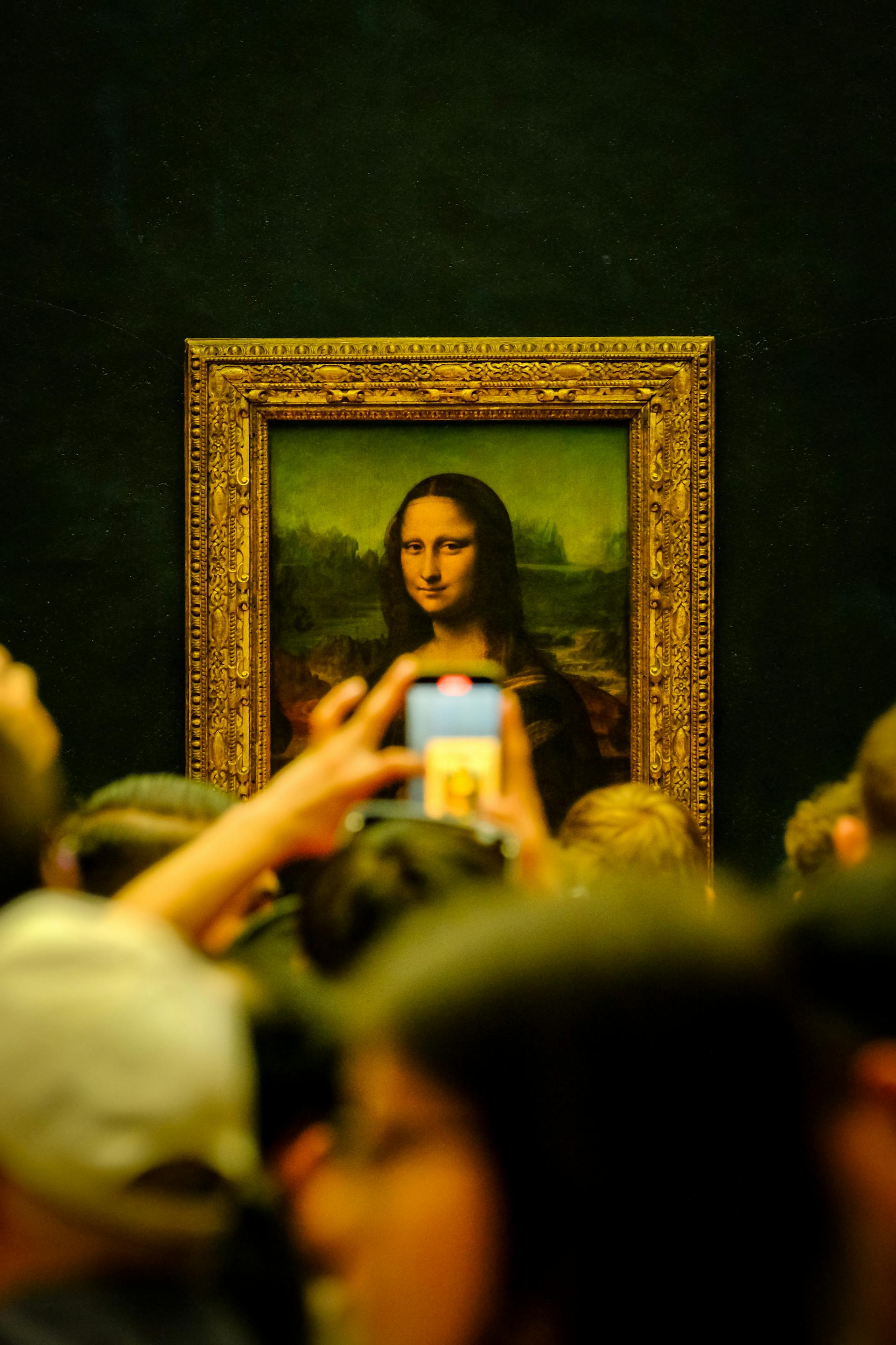 Gente mirando el cuadro de la Mona Lisa en una galería | Fuente: Pexels