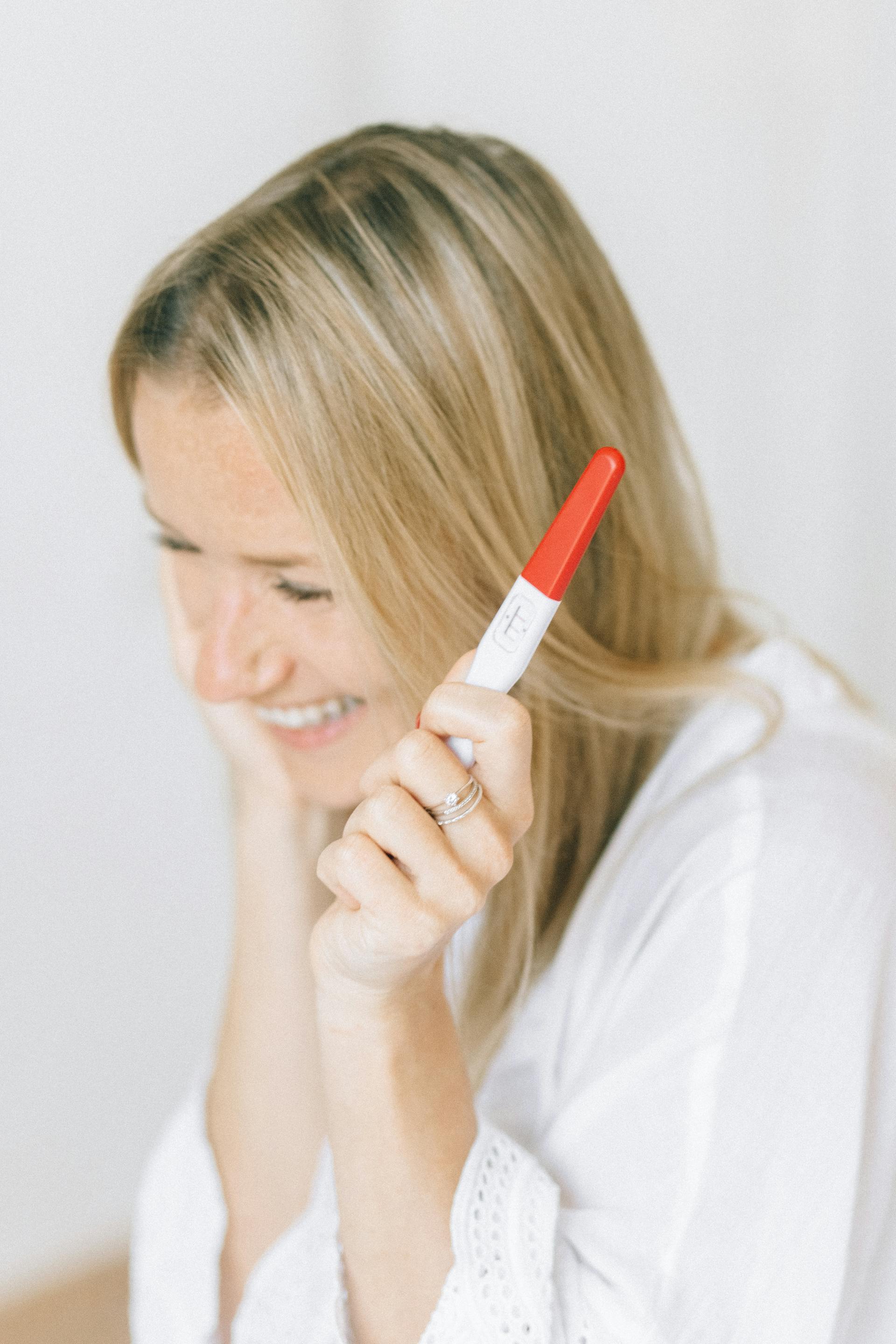 Una mujer feliz sosteniendo una prueba de embarazo | Fuente: Pexels
