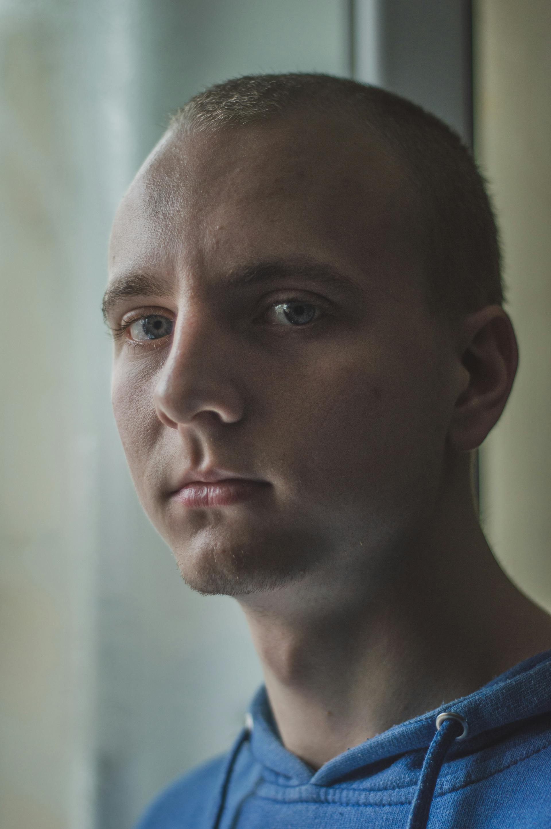 Un hombre con el pelo corto y los ojos azules mirando hacia delante | Fuente: Pexels