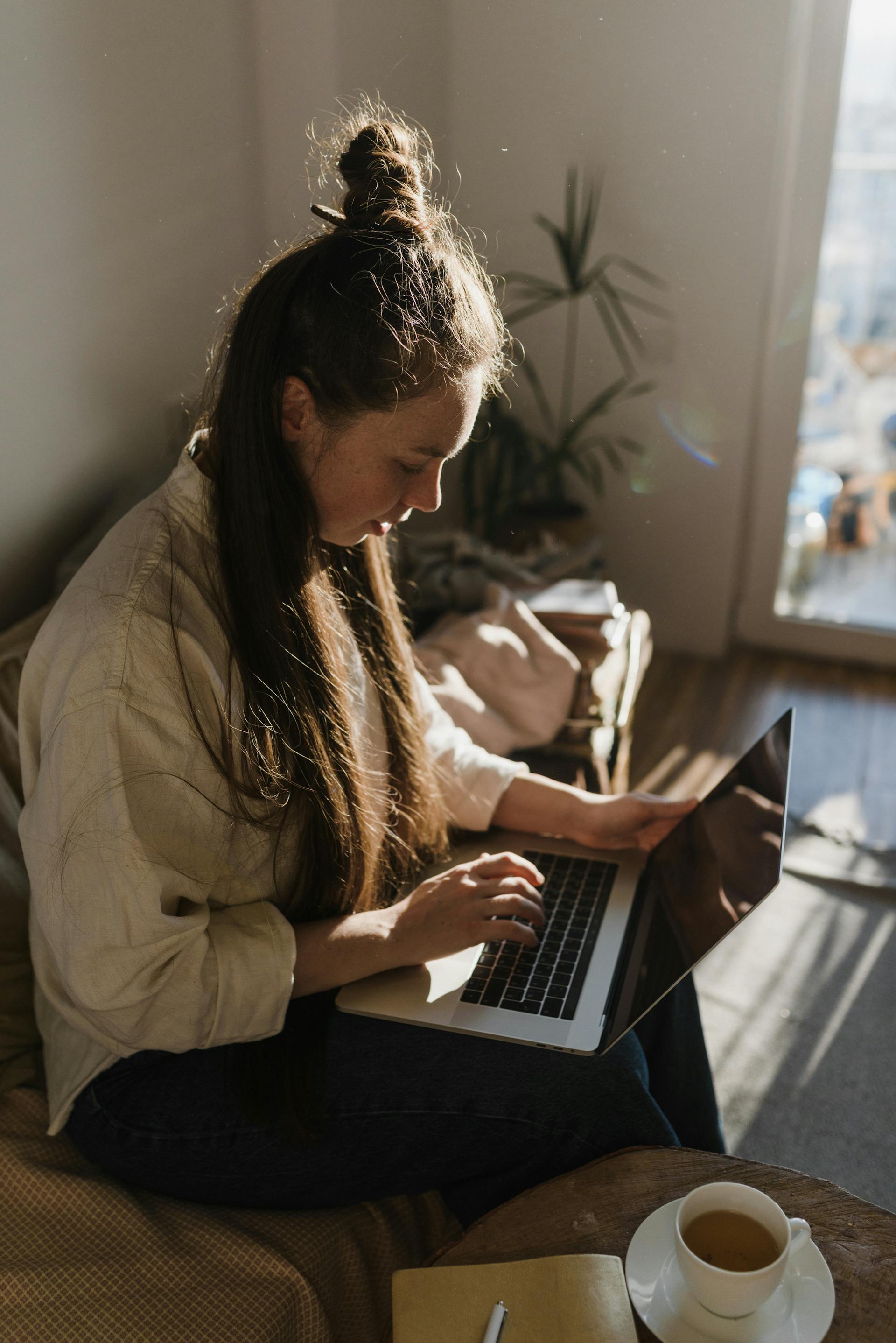 Una joven trabajando con su portátil | Fuente: Pexels