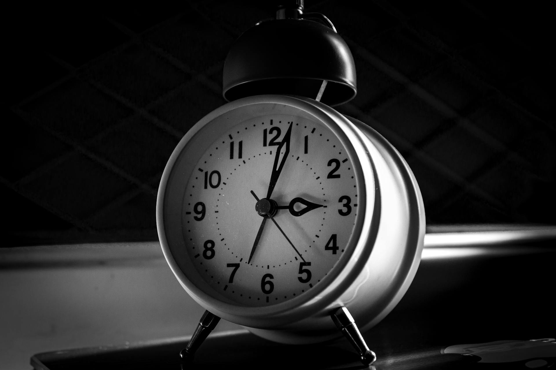 Foto en escala de grises de un despertador | Fuente: Pexels