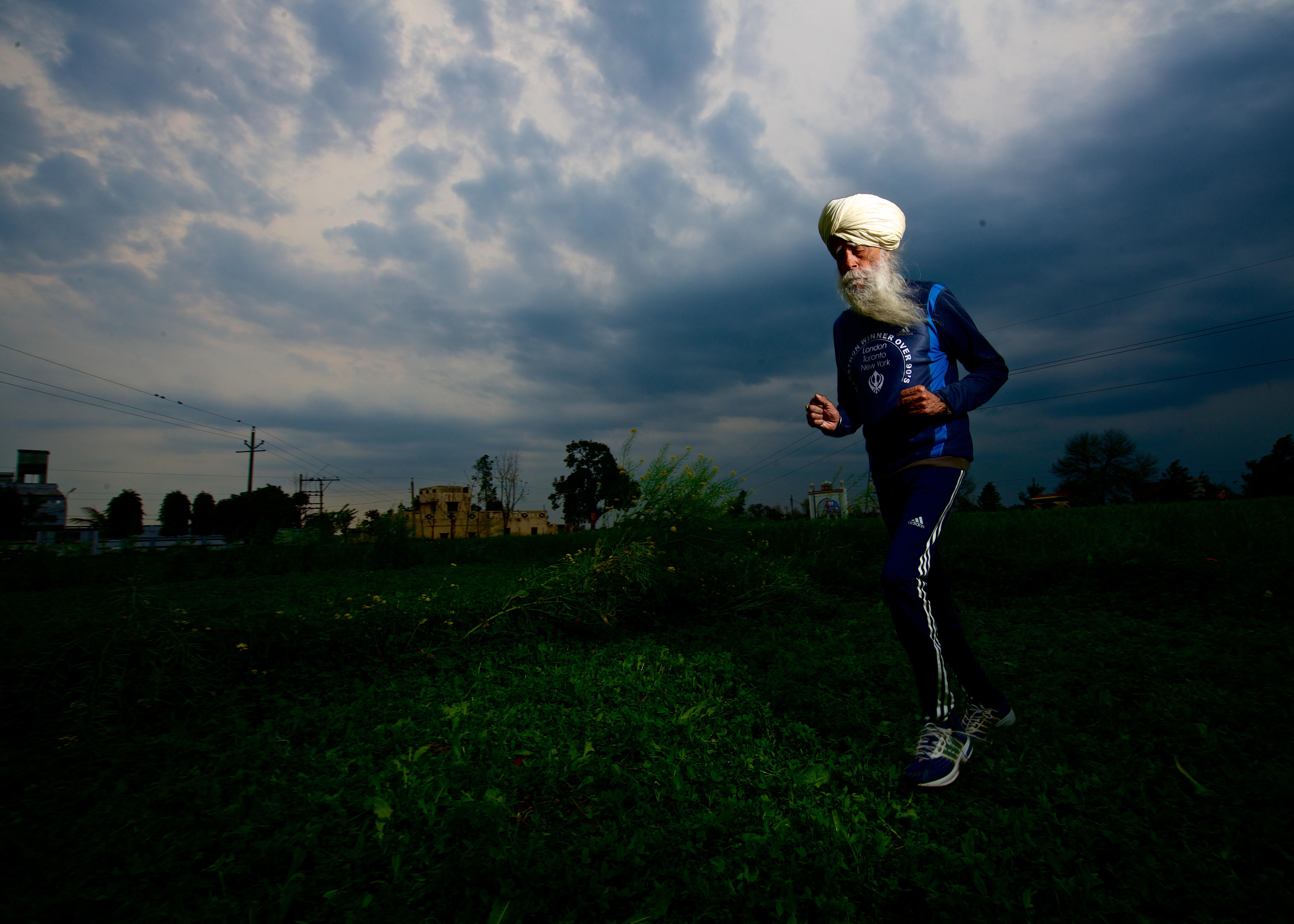 Fauja Singh, a los 102 años, corriendo en su casa de Beas, India, el 20 de marzo de 2014. | Fuente: Getty Images