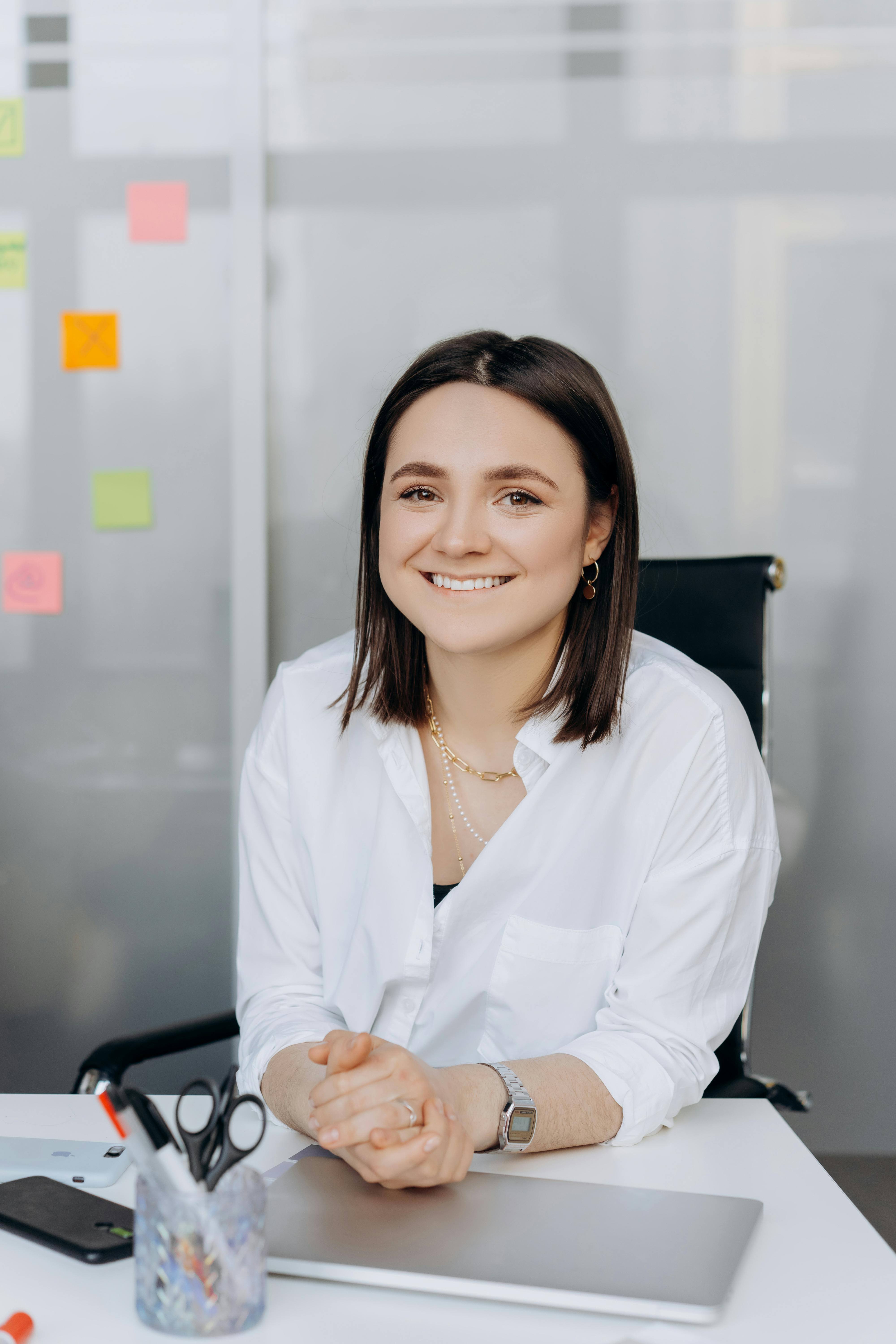 Una mujer feliz en una oficina | Fuente: Pexels