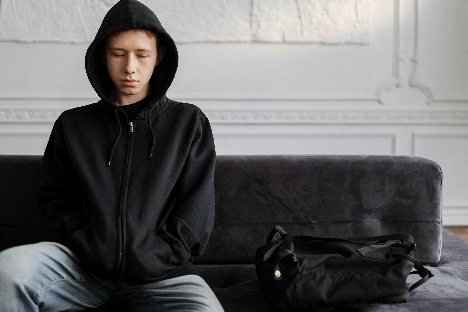 Adolescente desanimado sentado en el sofá | Fuente: Pexels